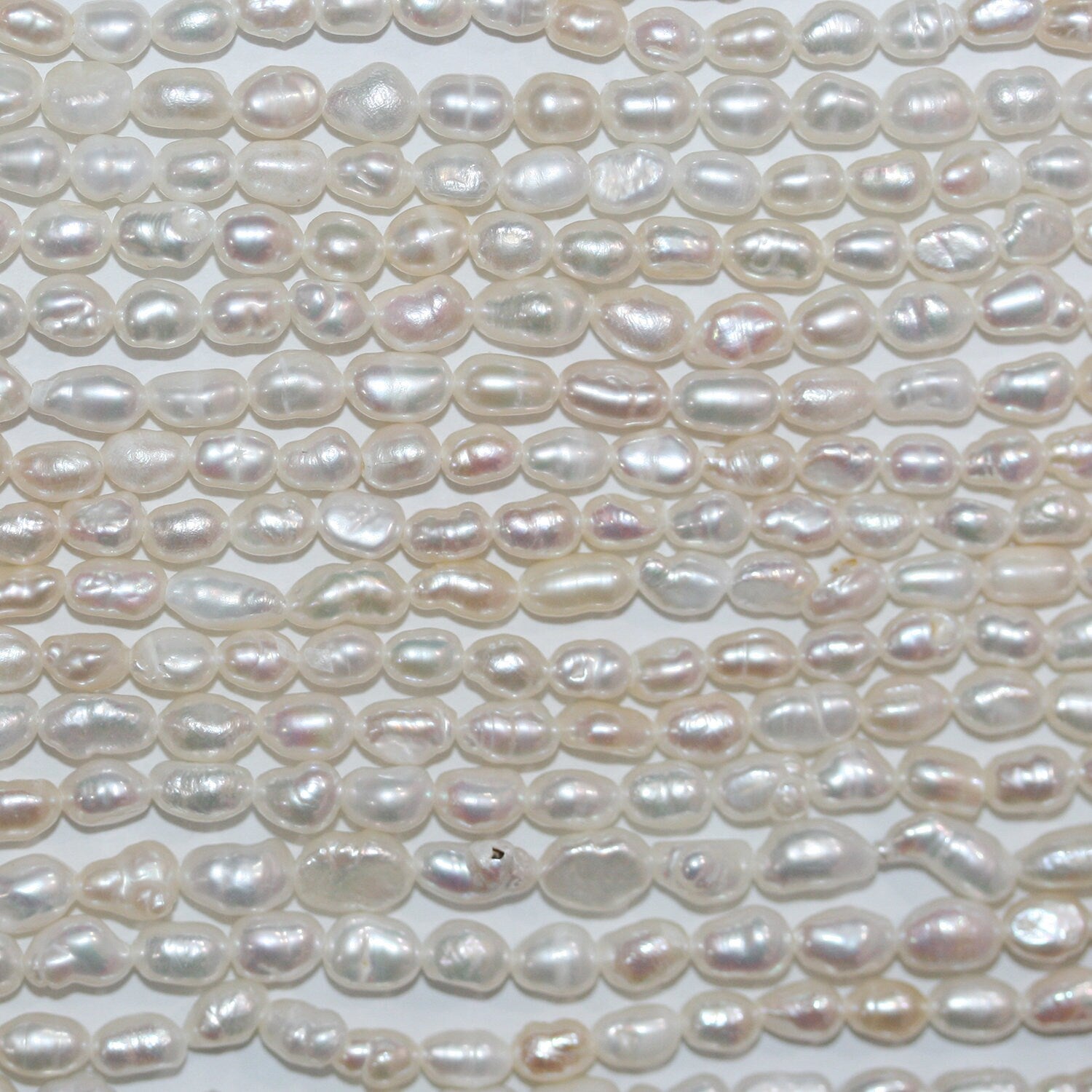 Perles ovales d'eau douce de 35 cm (14 pouces), 3-4 mm, en rang de 35 cm. Perles naturelles à prix de gros.