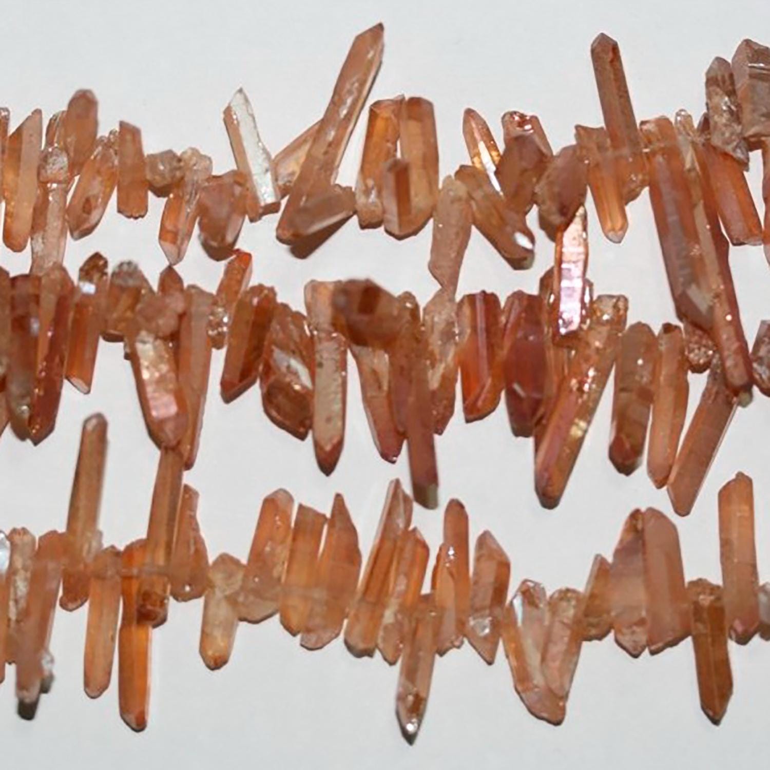 Bâtonnets de perles de quartz brun clair non polies, 12-25 x 4 mm environ. Longueur du brin : 40 cm.