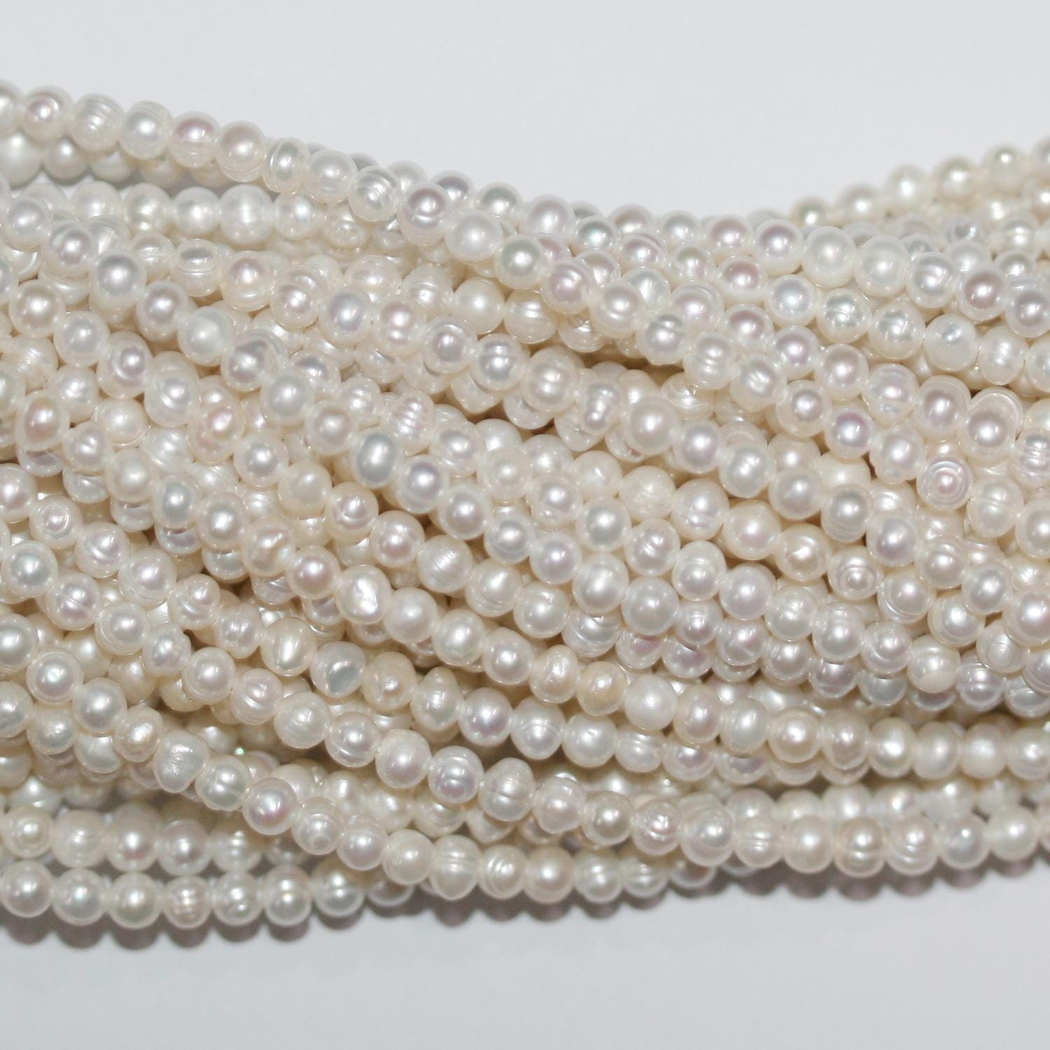 Perla de agua dulce redonda de 14" de St. 3,5-4 mm. - Hilo de 37 cm.