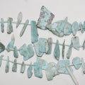 Perles de larimar St irrégulières, lisses et plates, à dégradé de 10 à 30 mm environ - Fil de 39 cm