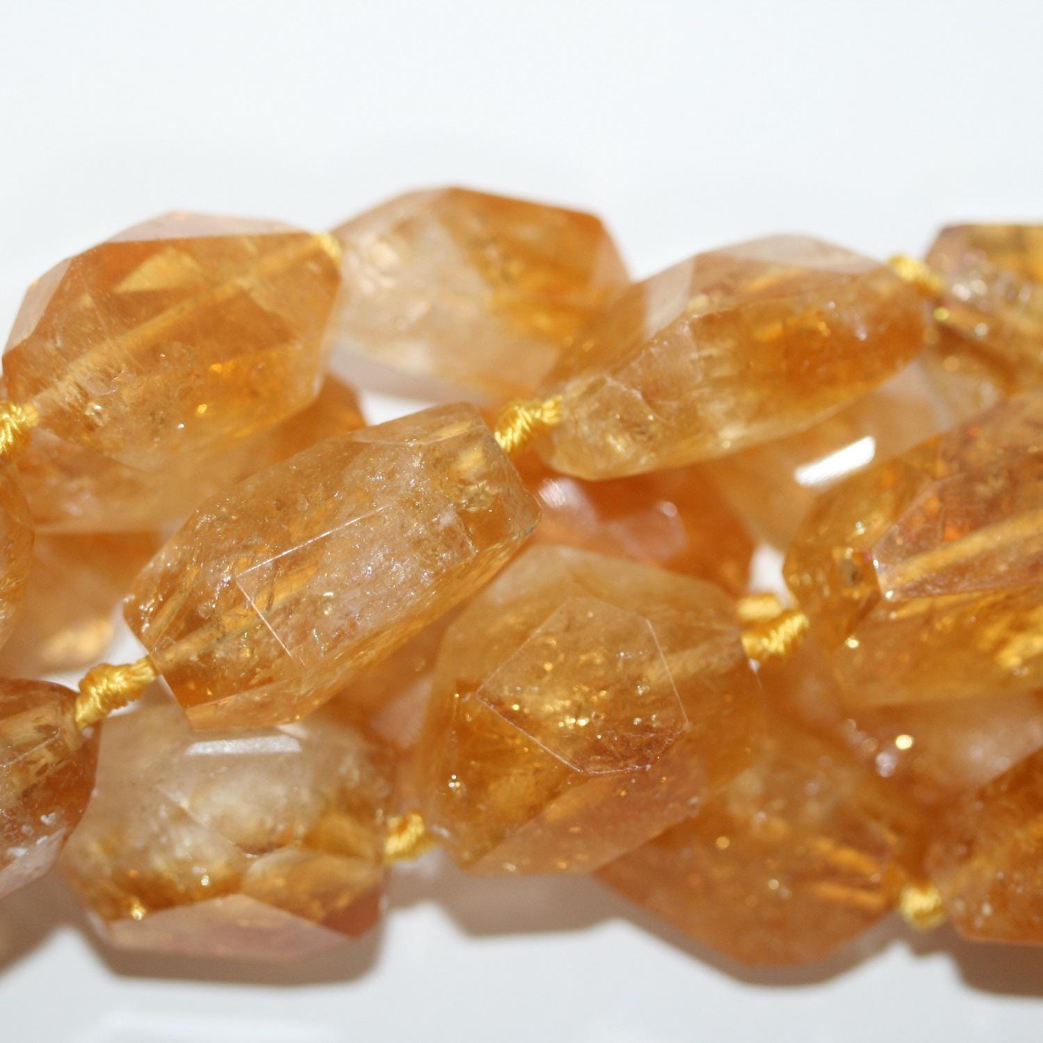 Perles de citrine facettées en forme de pépite de 15 pouces (26 x 14 mm). Longueur approximative du brin : 39 cm.