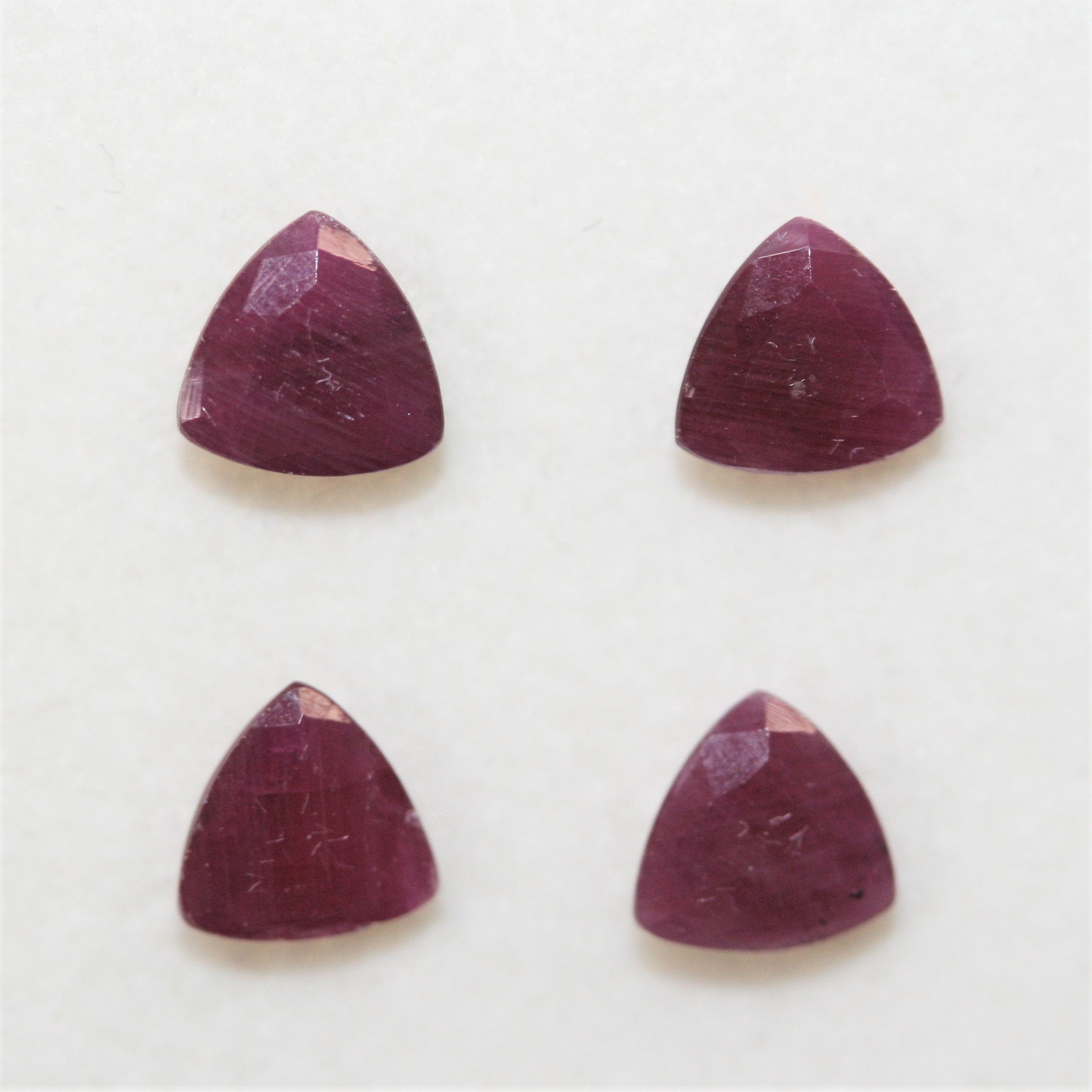 Lot de 4 rubis facettés taille trillion de 6 mm.