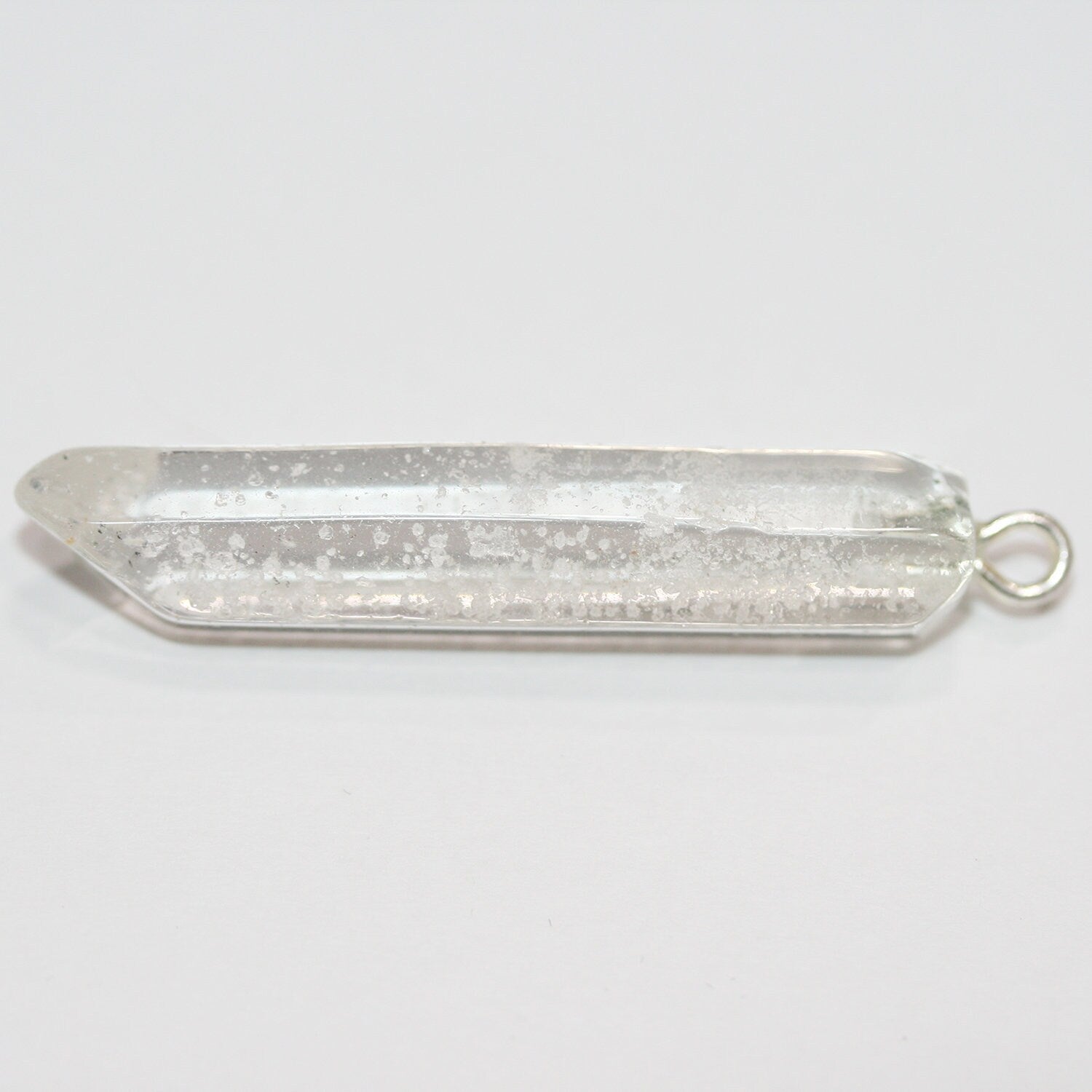 Pendentif en quartz cristal de roche facetté, forme bâtonnet irrégulière, 50 x 7 mm environ (1 pièce).