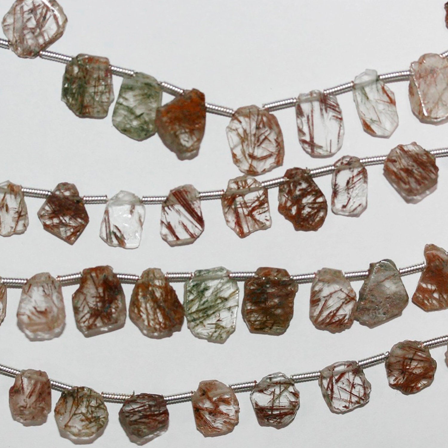 Perles ovales lisses et irrégulières en quartz rutile de 8 à 10 mm de diamètre. Longueur du fil : environ 21 cm.