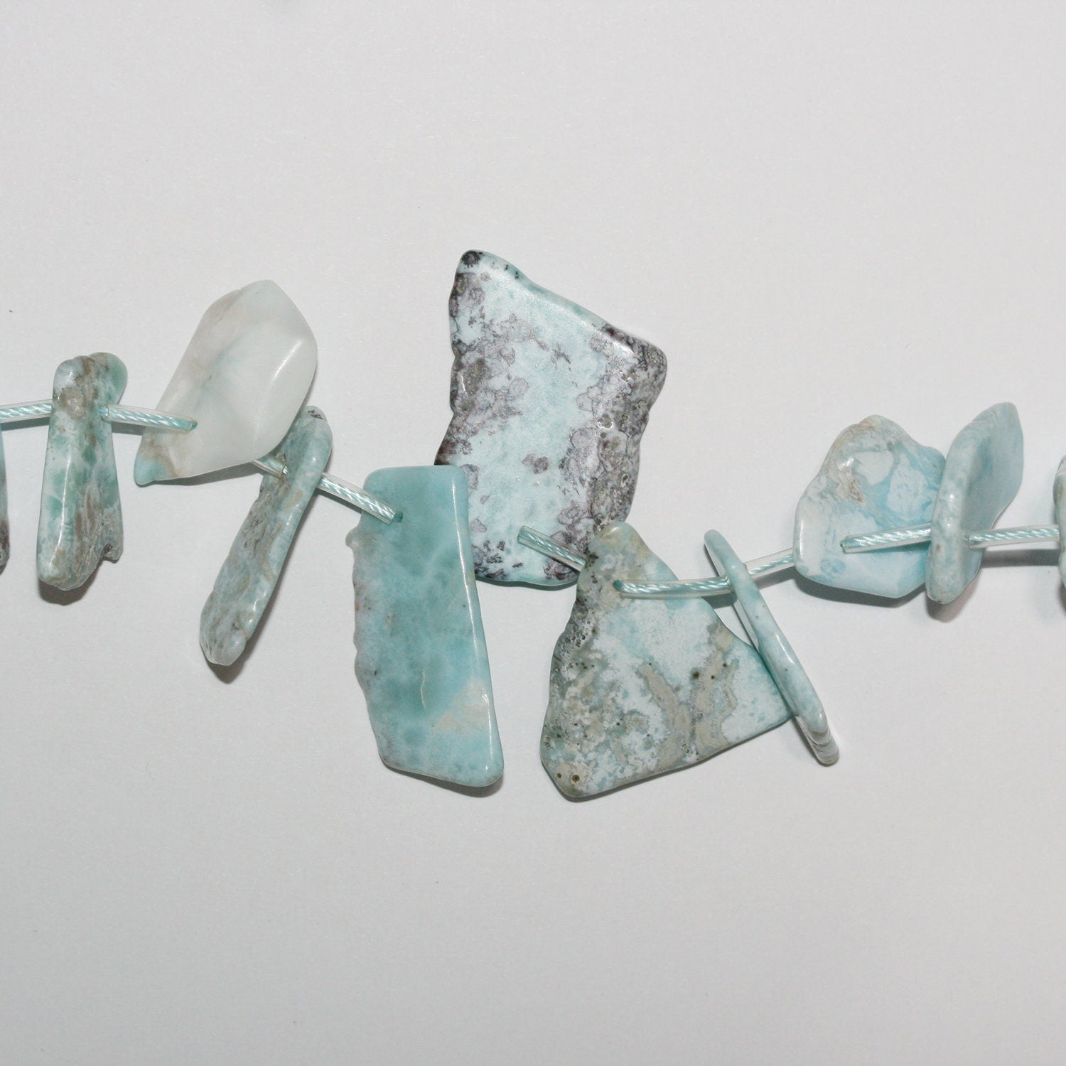 Perles de larimar St irrégulières, lisses et plates, à dégradé de 10 à 30 mm environ - Fil de 39 cm