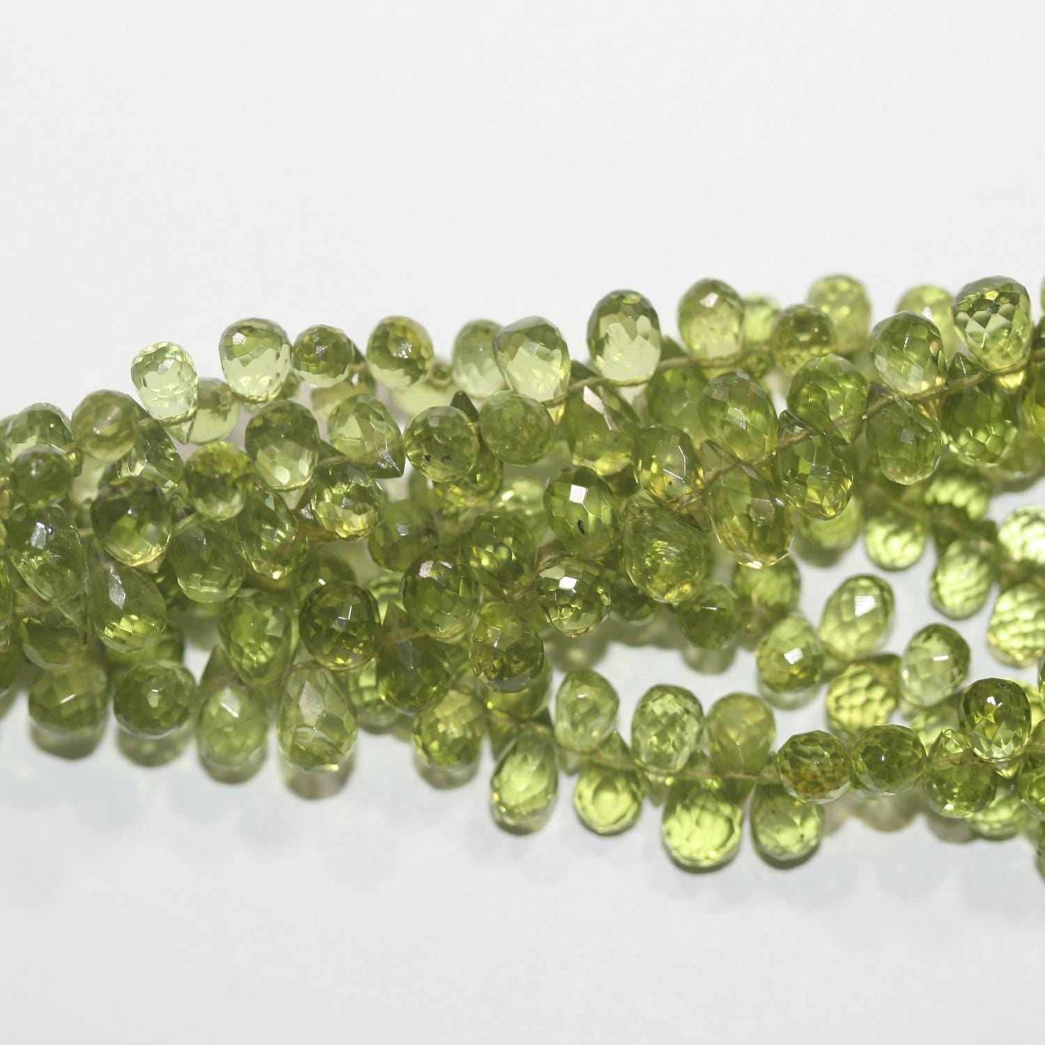 Perles en péridot facettées de 8 pouces (7 x 4 mm). Longueur approximative du fil : 20 cm.