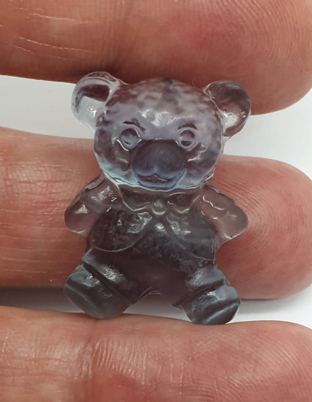 Colgante de fluorita tallada en forma de oso de peluche (26 x 20 mm). Con orificio para el colgante.