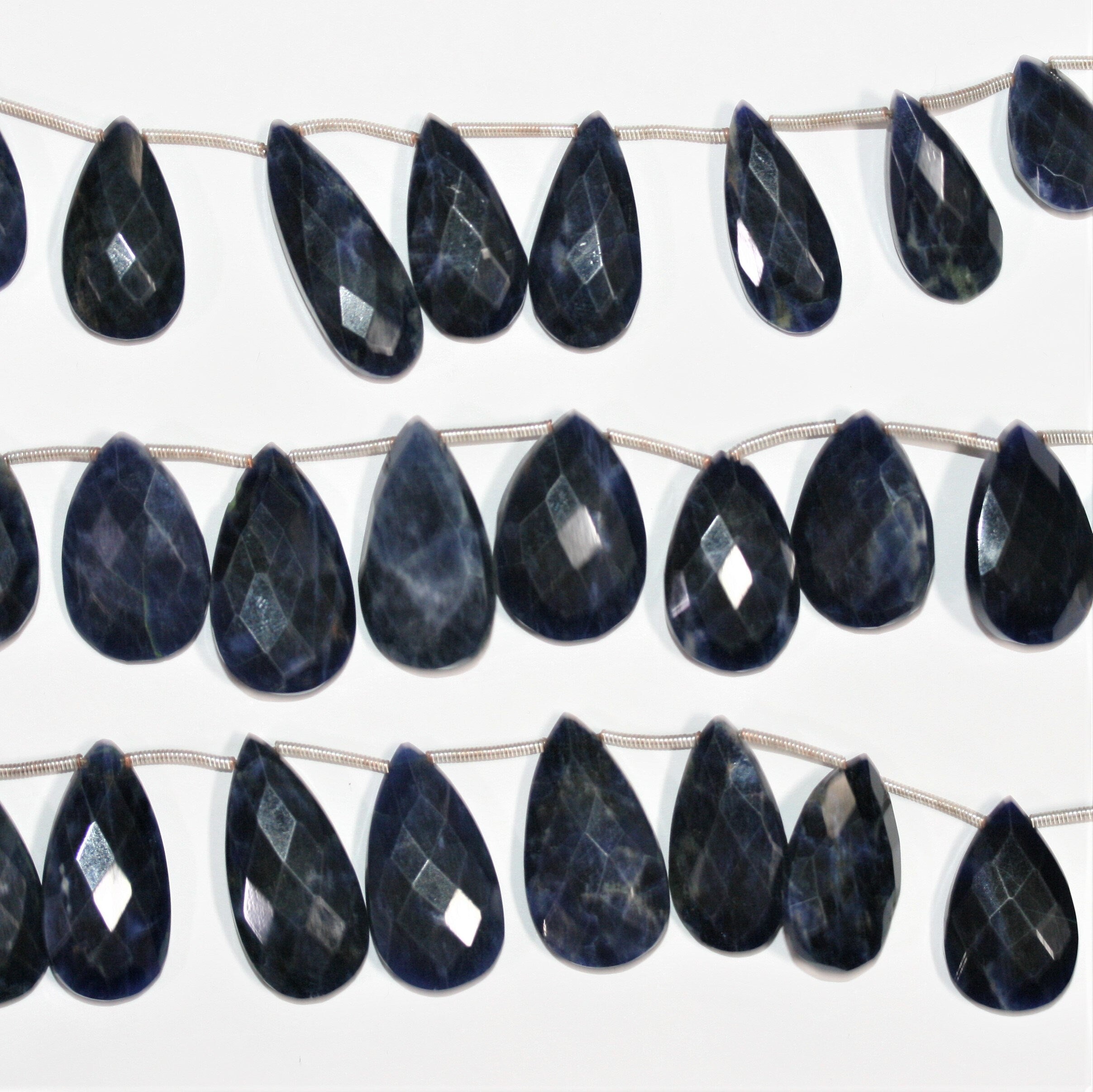 Perles en sodalite St de taille graduée, en forme de goutte, à facettes, de 17 x 10 à 29 x 15 mm. Longueur approximative du fil : 20 cm.