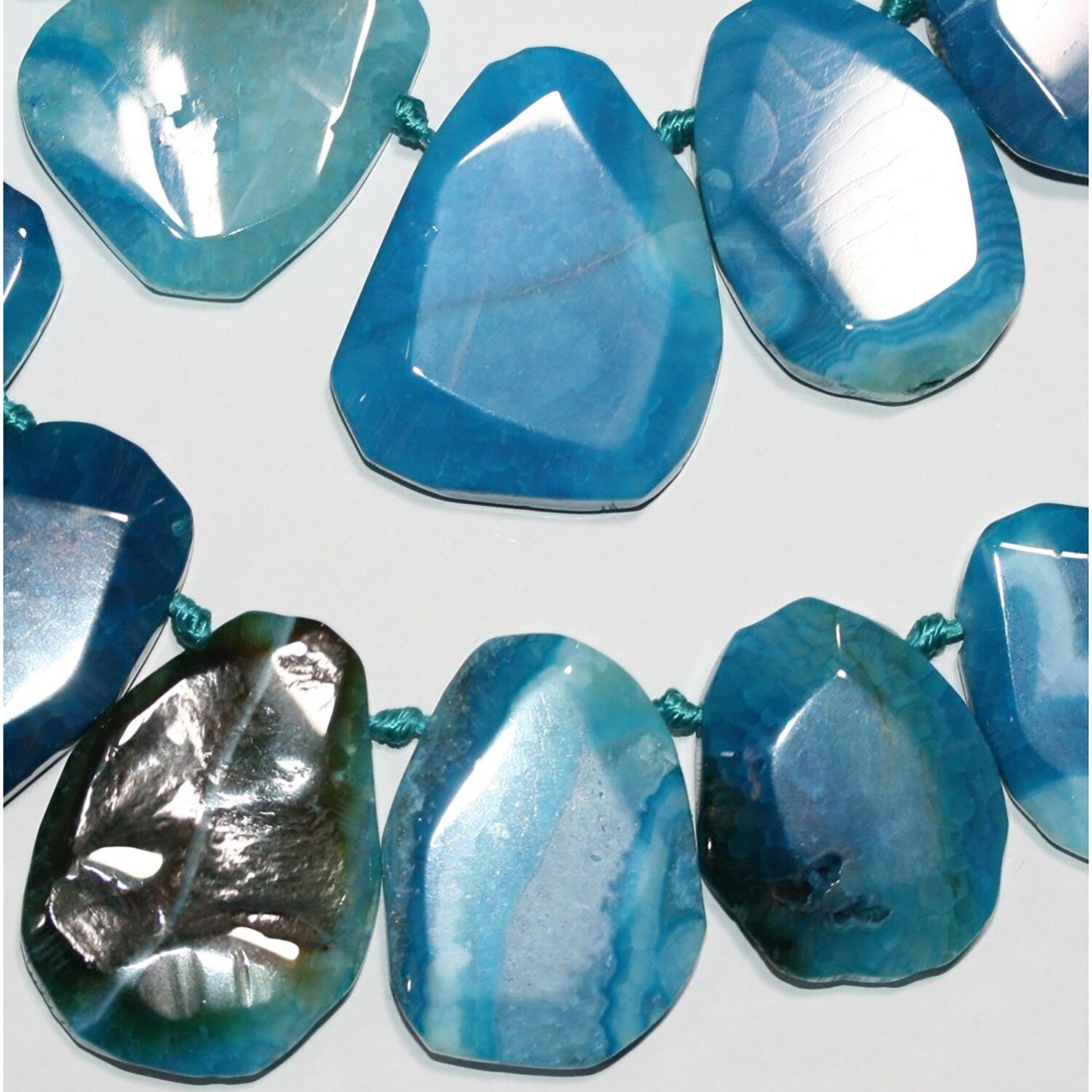 Cuentas ovaladas irregulares de ágata azul de 40 cm, graduadas, de 25 x 18 a 41 x 32 mm. Tira de aproximadamente 40 cm.