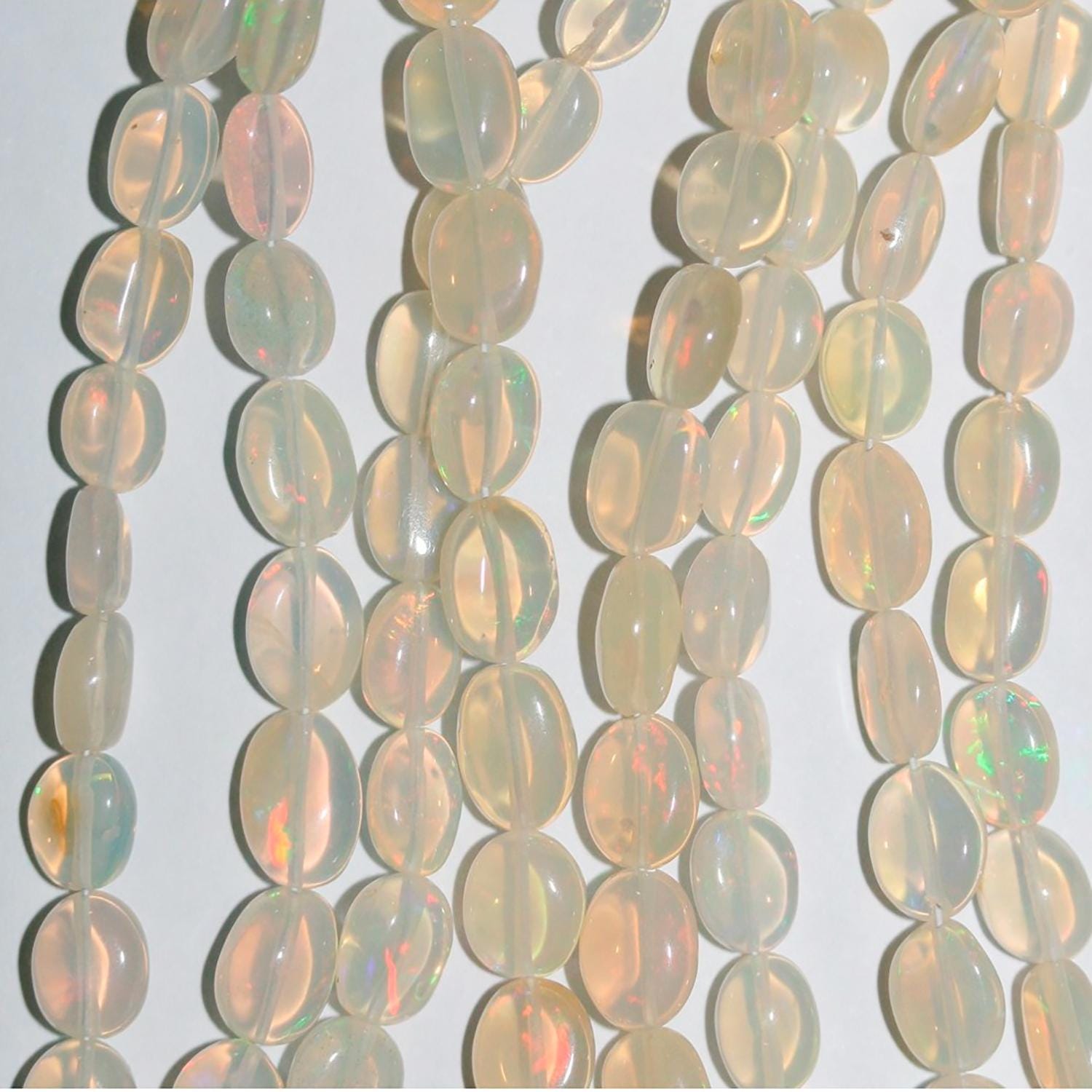 Perles ovales lisses dégradées en opale éthiopienne St de 40 cm (16 pouces), de 6 x 4 à 10 x 7 mm environ. Longueur du fil : 42 cm.