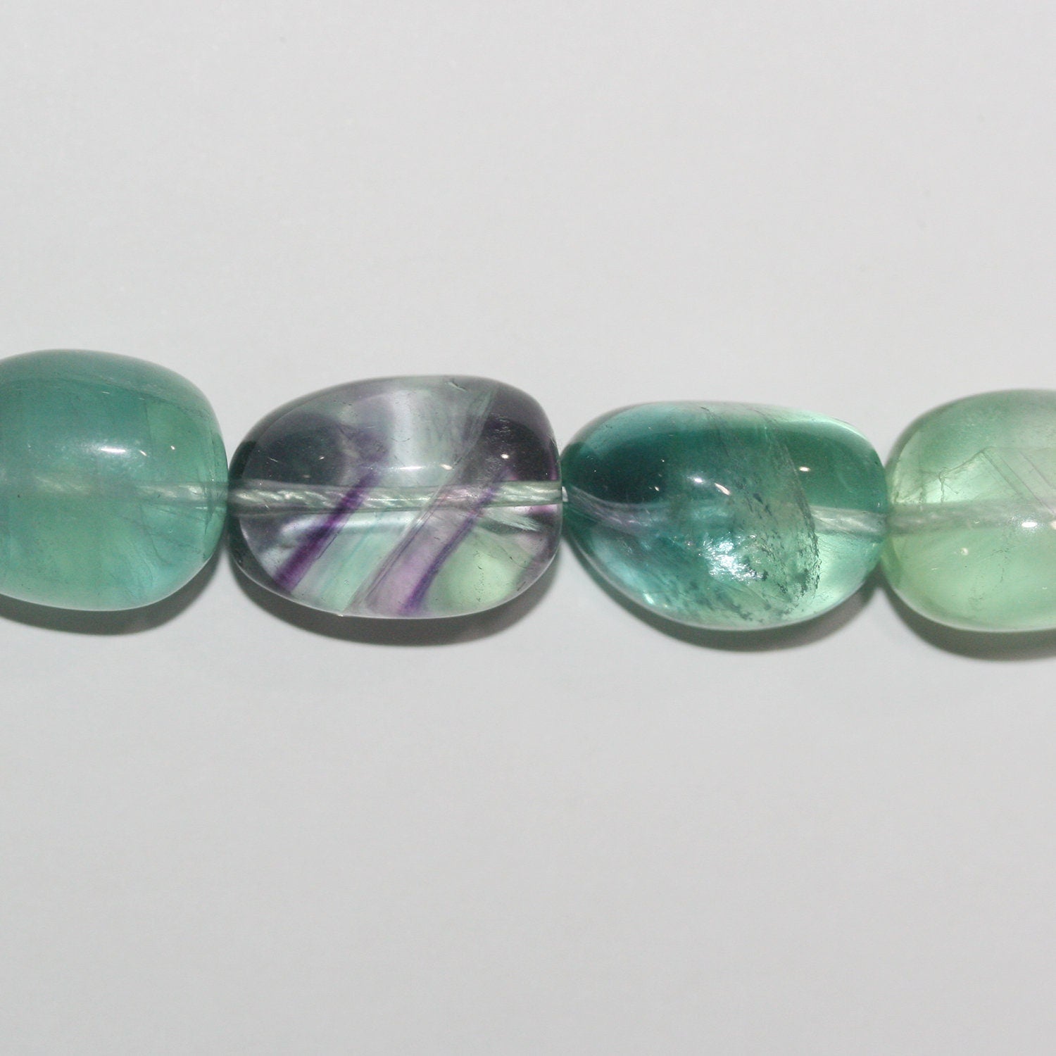 Perles de fluorite St lisses en forme de pépites, 18 x 15 mm. Longueur approximative du brin : 39 cm.