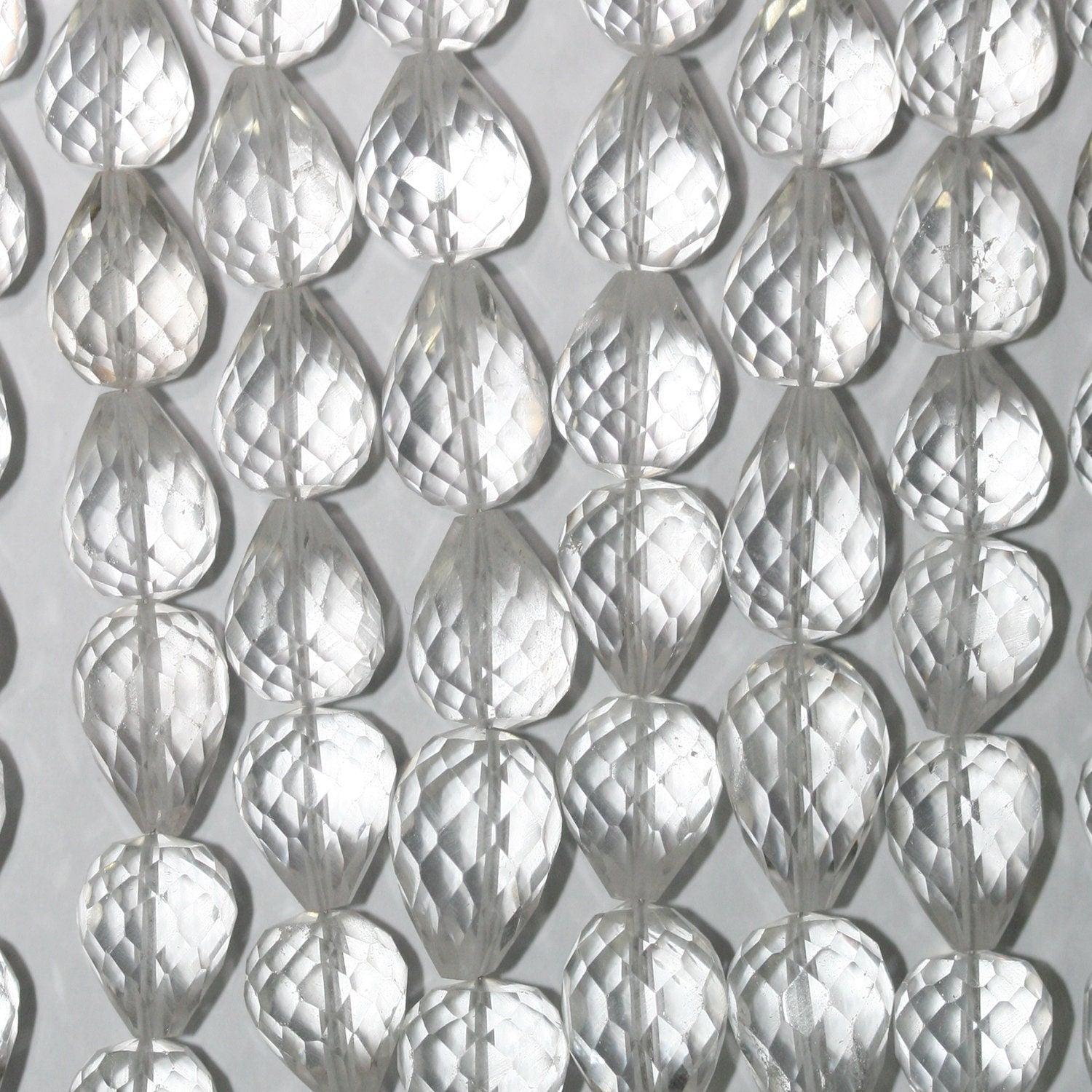 Perles en cristal de roche facettées en forme de goutte, 11 x 8 mm environ. Longueur du fil : 21 cm. Perles percées sur le dessus.