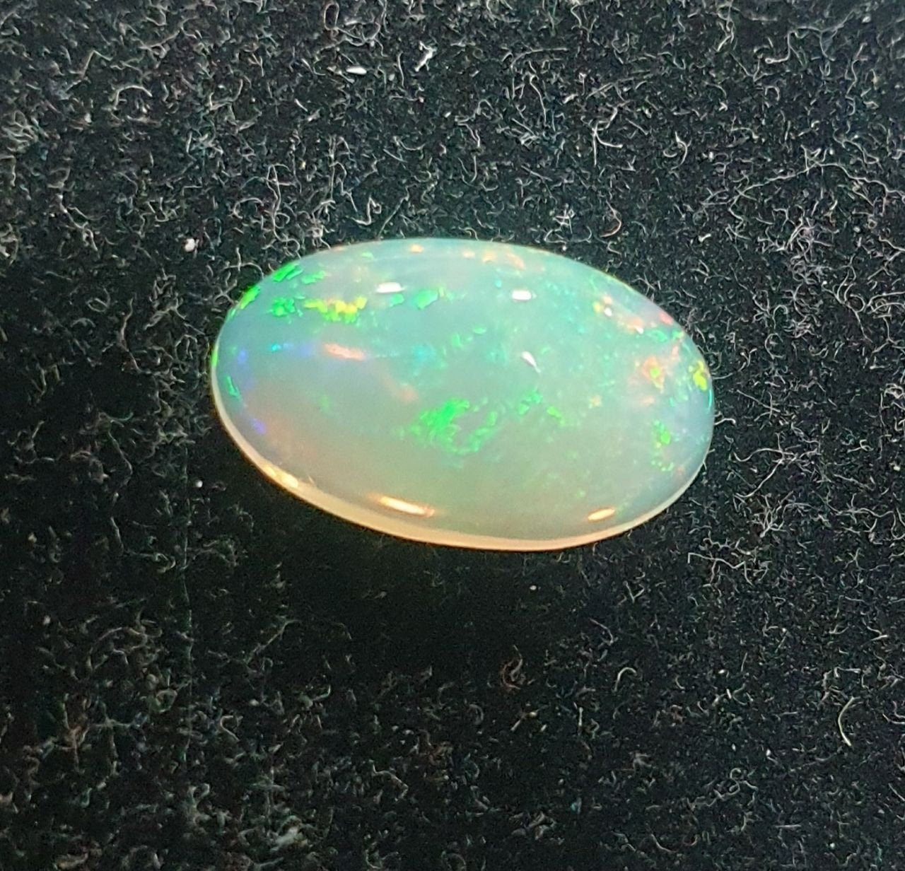 Cabujón ovalado de ópalo blanco AAA de 13,1 x 8 mm y 2,37 ct. Ópalo natural sin tratar. Gran intensidad de color. Talla excepcional.
