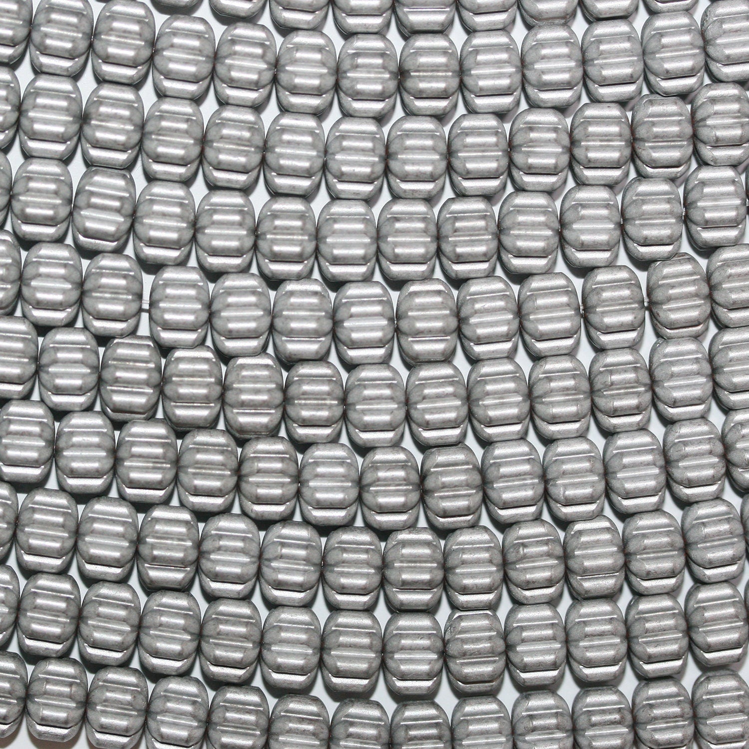 Cuentas redondas talladas en hematita plateada de 16" con acabado mate de 8 x 5 mm.