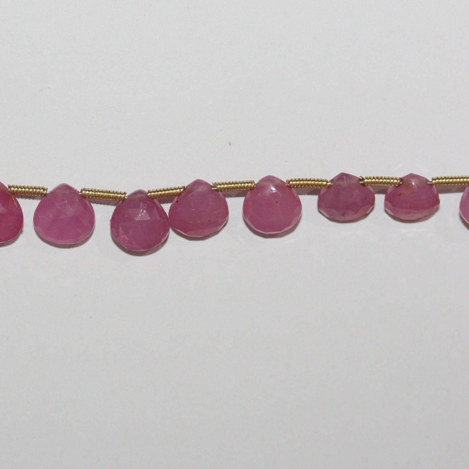 Perles en saphir rose St de taille dégradée, en forme de goutte, de 5 à 7 mm. Longueur approximative du fil : 21 cm.