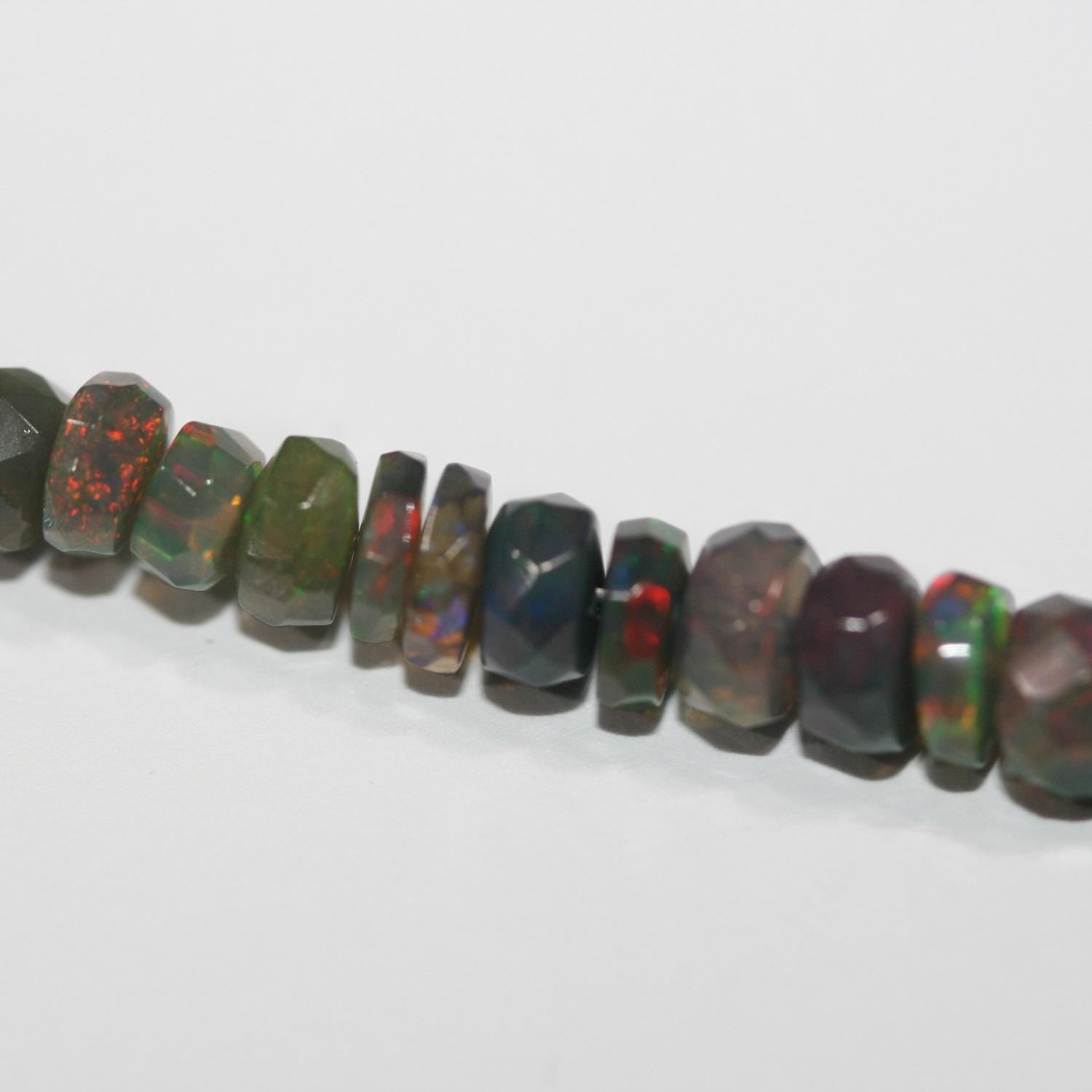 Cuentas redondas facetadas de ópalo etíope negro de 40 cm. 6,4 x 3,4 mm - 3,3 x 2,5 mm. Hilo de 40 cm.