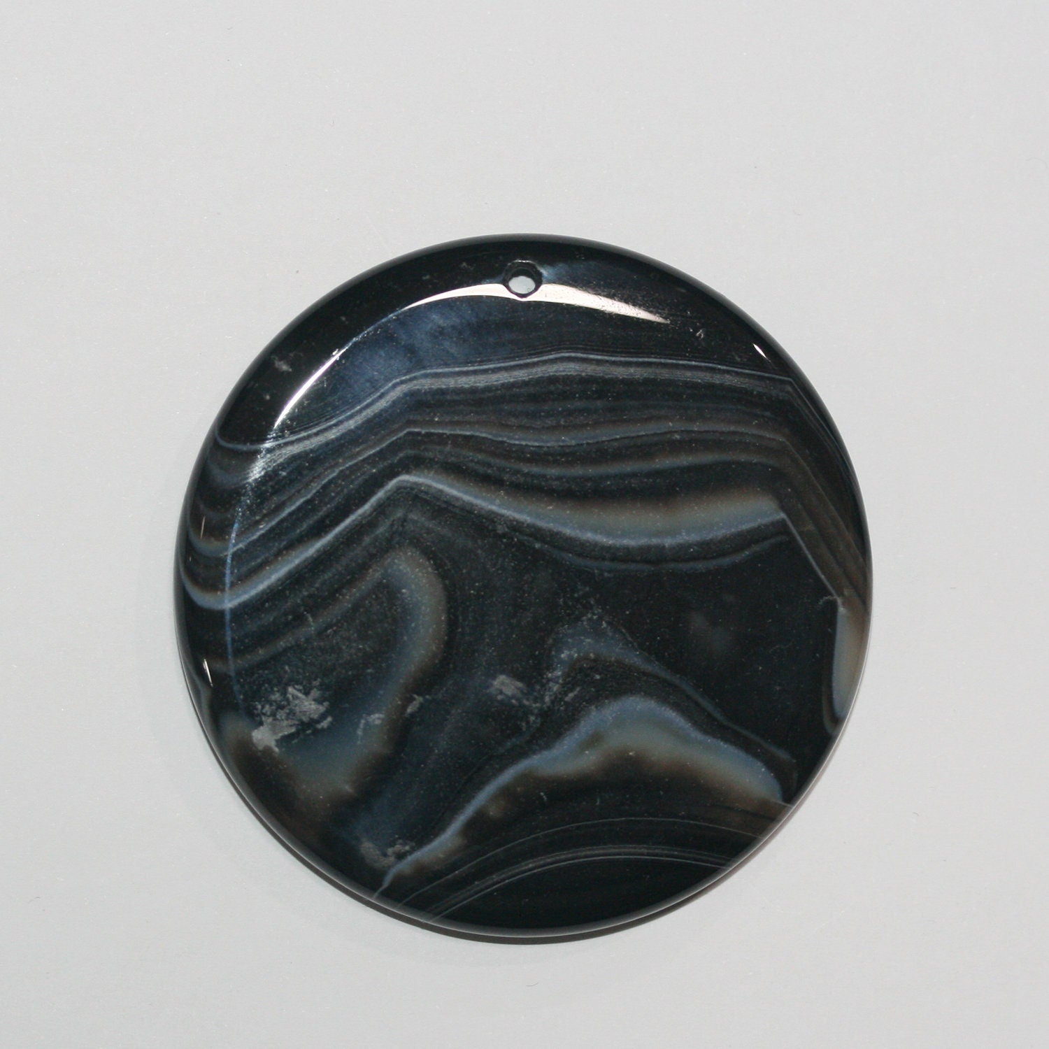 Pendentif rond lisse en onyx rayé 56 mm.