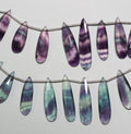 Perles en fluorite St de taille graduée, facettes, en forme de goutte, 16 x 6 à 30 x 8 mm environ. Longueur du fil : 20 cm.
