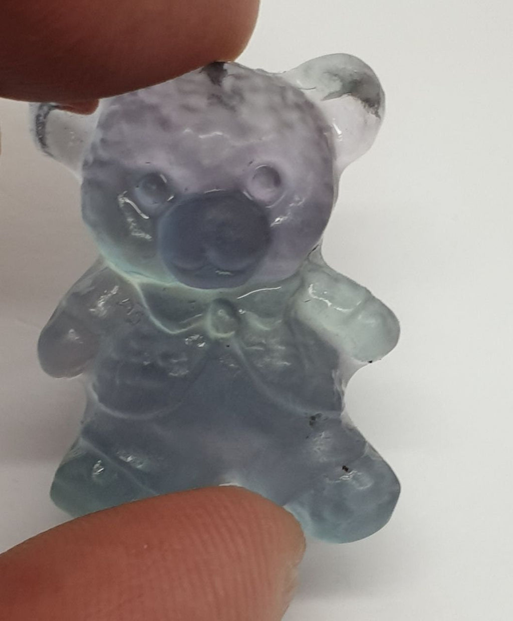 Colgante de fluorita tallada en forma de oso de peluche (26 x 20 mm). Con orificio para el colgante.
