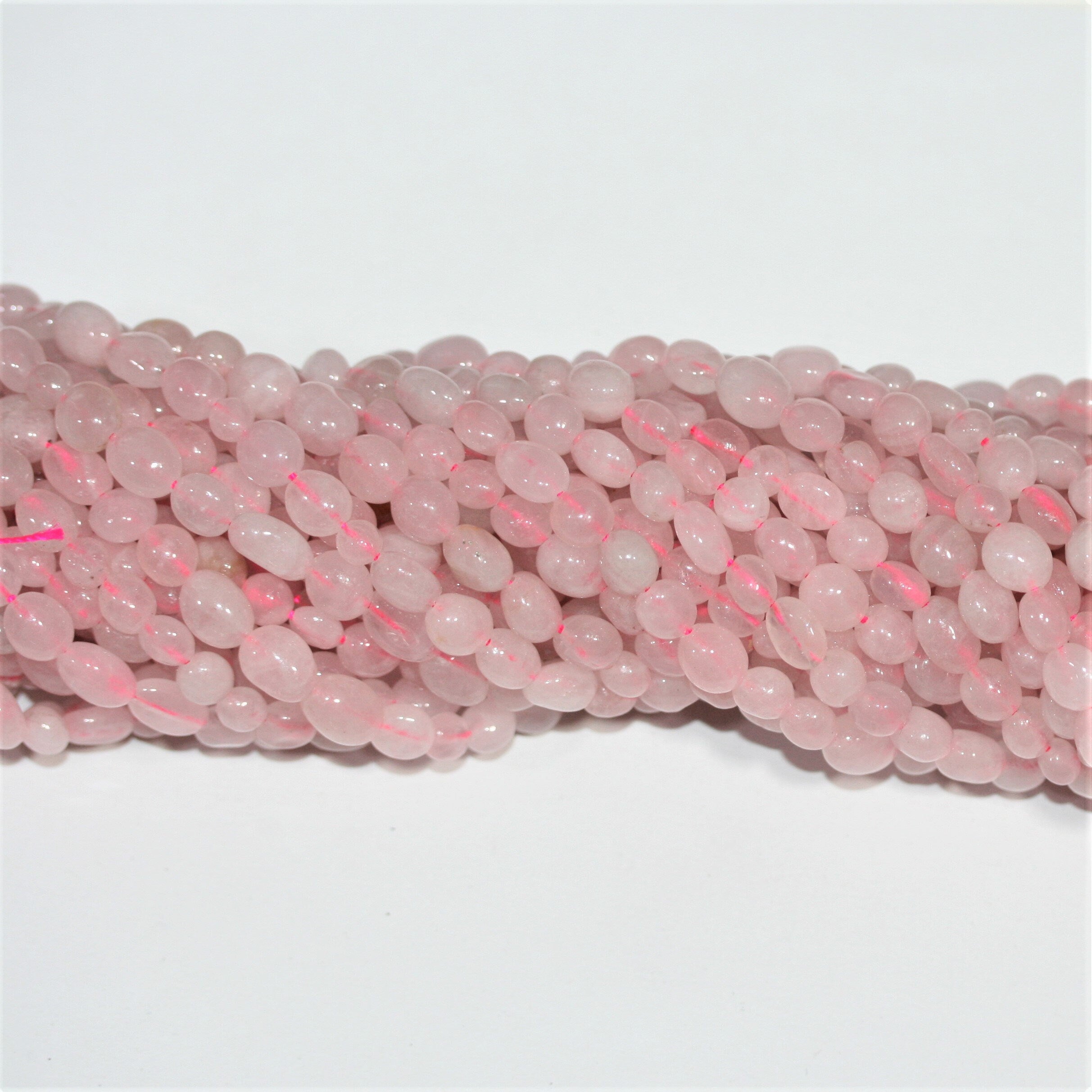 Perles de quartz rose St. Rose lisses en pépites de 15 pouces (6-8 mm). Longueur approximative du brin : 39 cm.