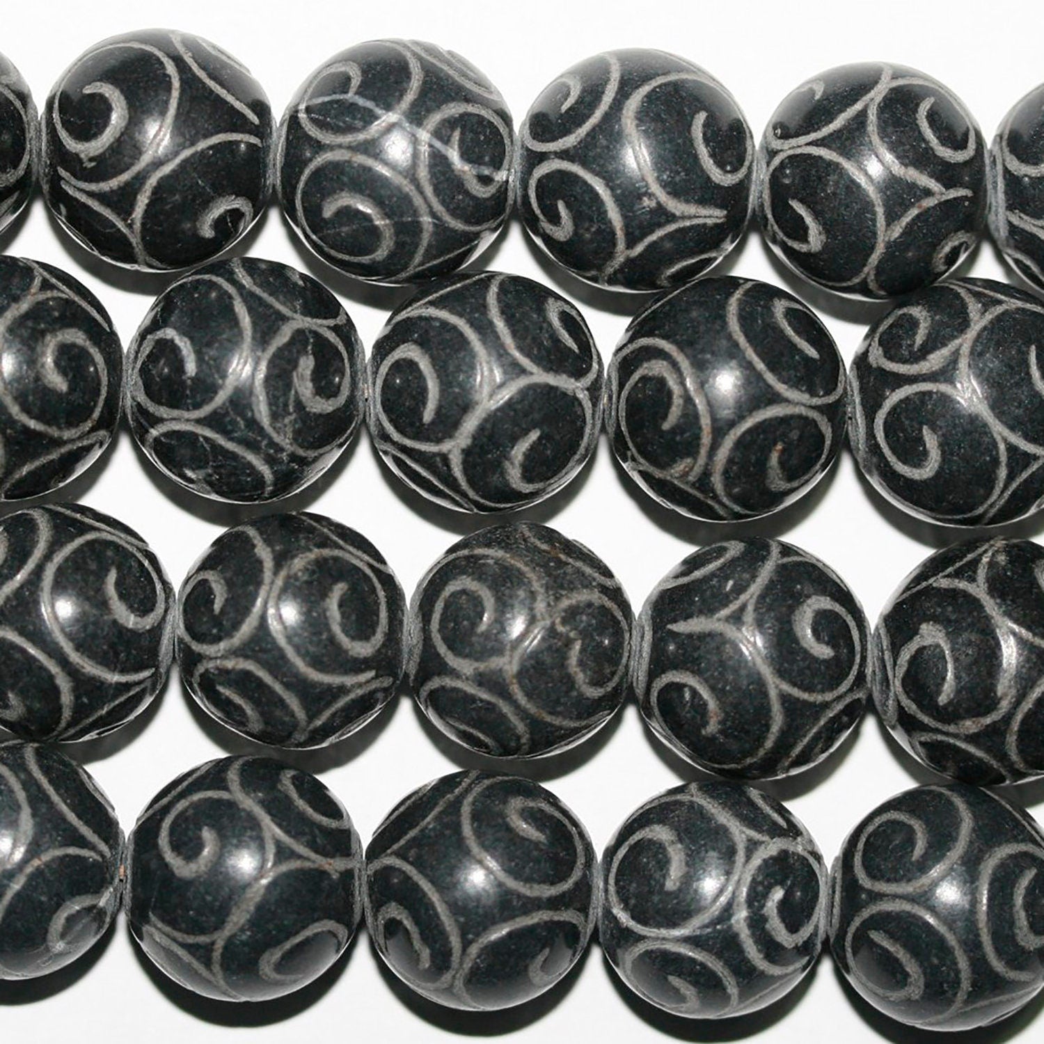 Perles rondes sculptées en jade 14 mm. - Fil de 130 cm environ.