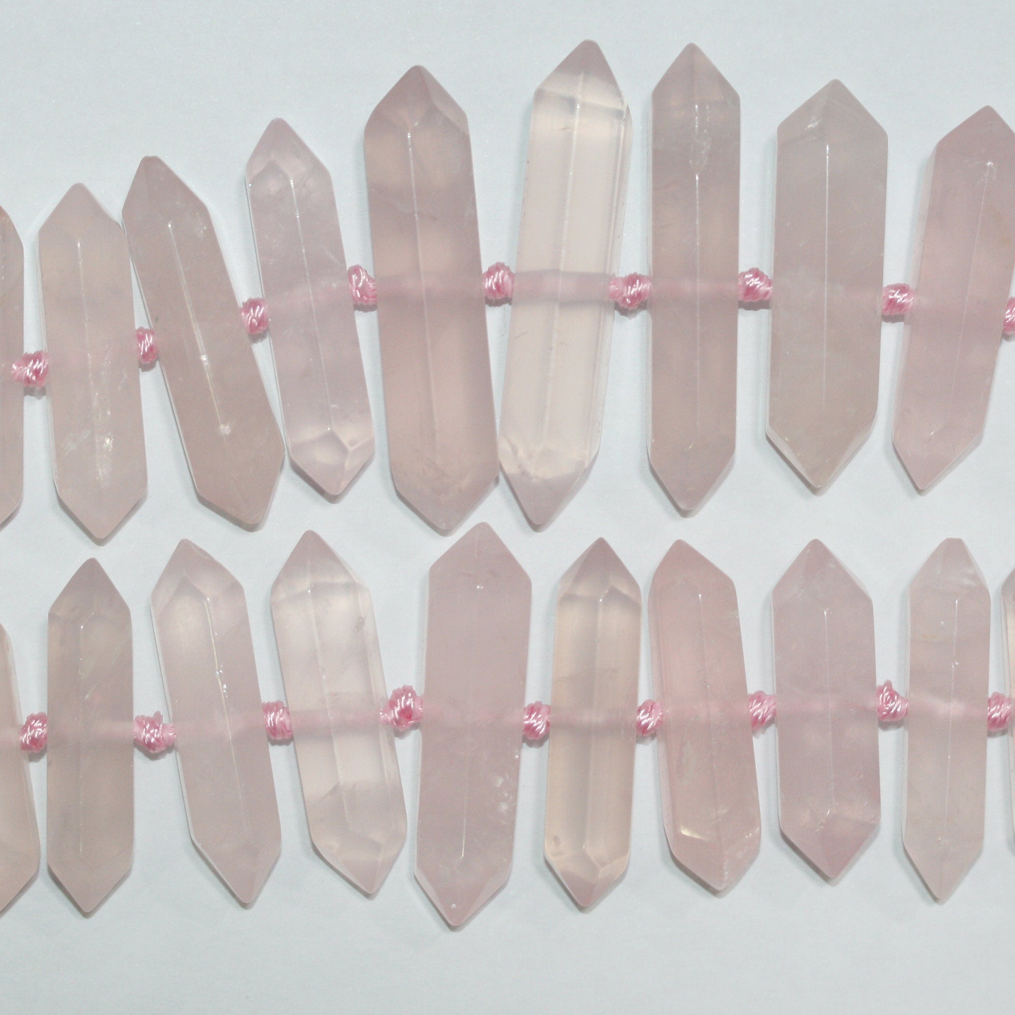 Perles de quartz rose St à facettes en forme de pointe de lance, 32 x 8 mm environ. Longueur du fil : 39 cm.