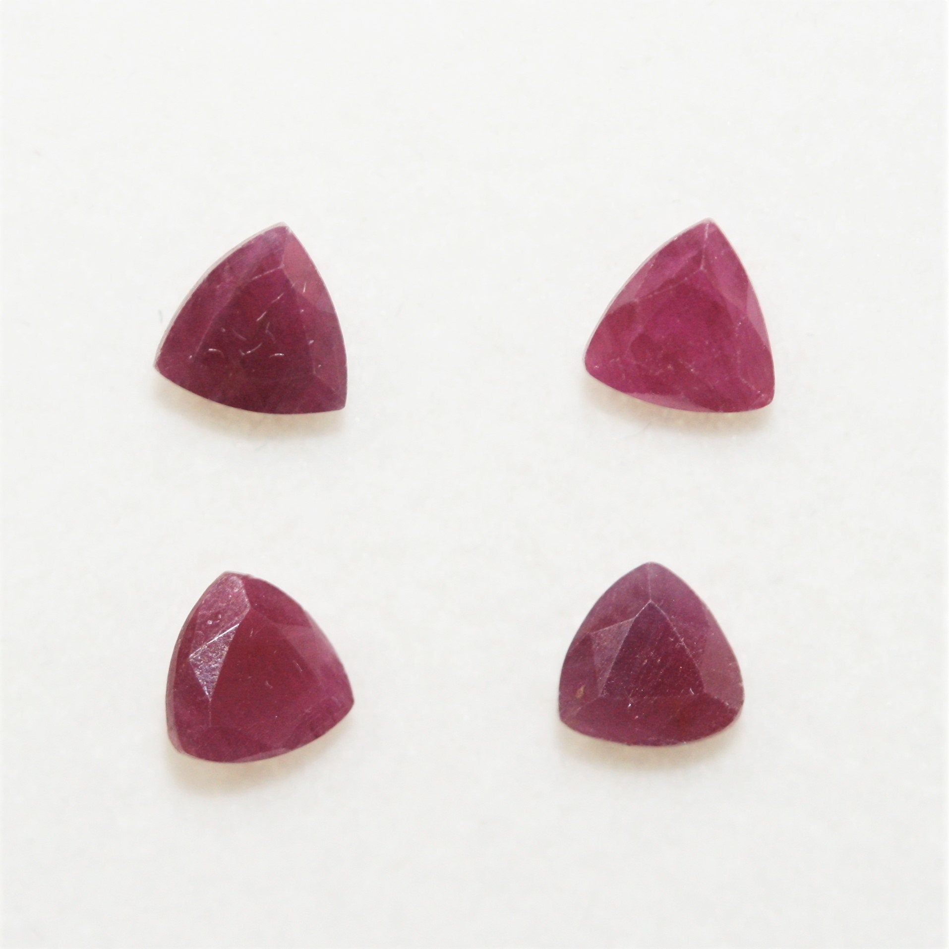 Lot de 4 rubis facettés taille trillion de 5 mm.