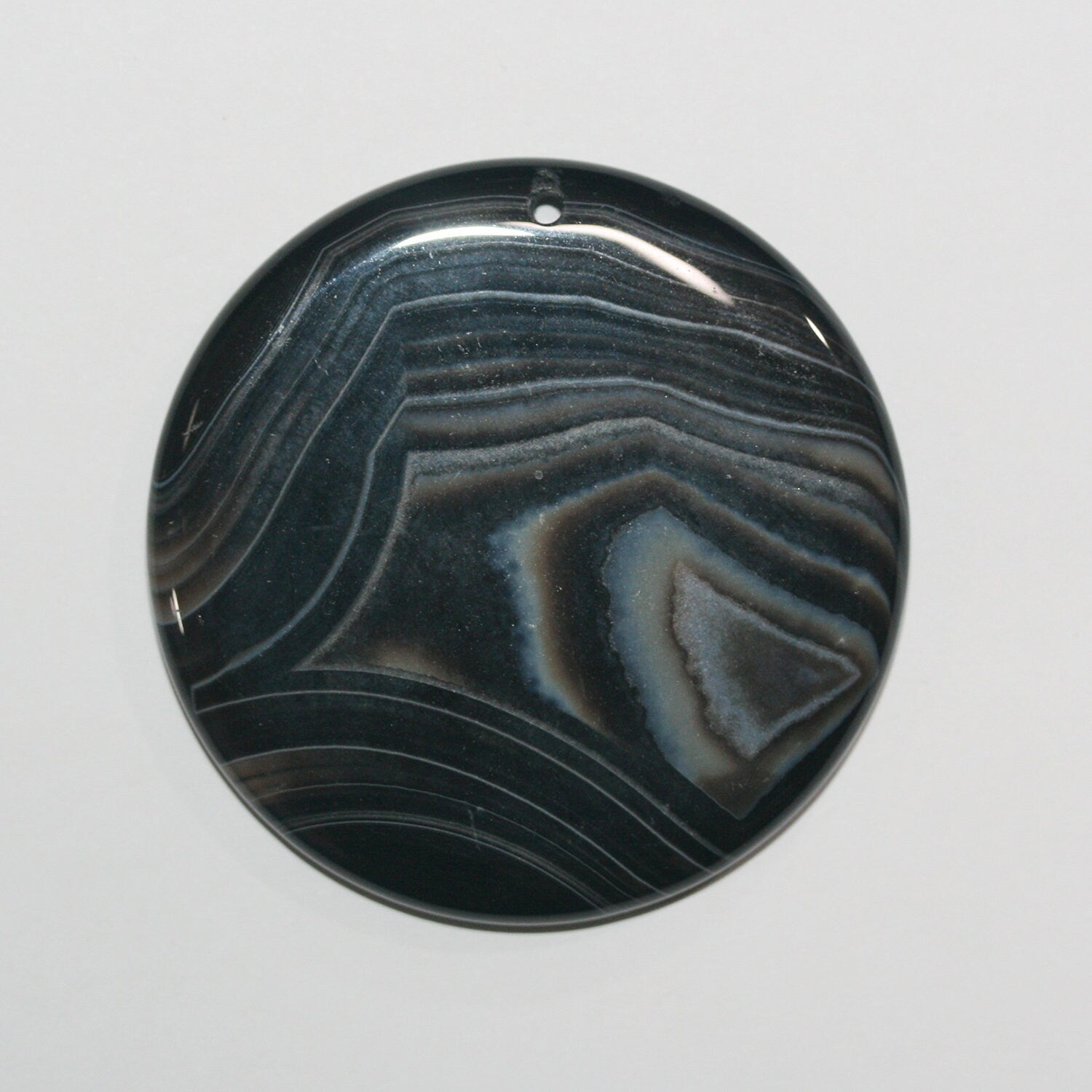 Pendentif rond lisse en onyx rayé 56 mm.