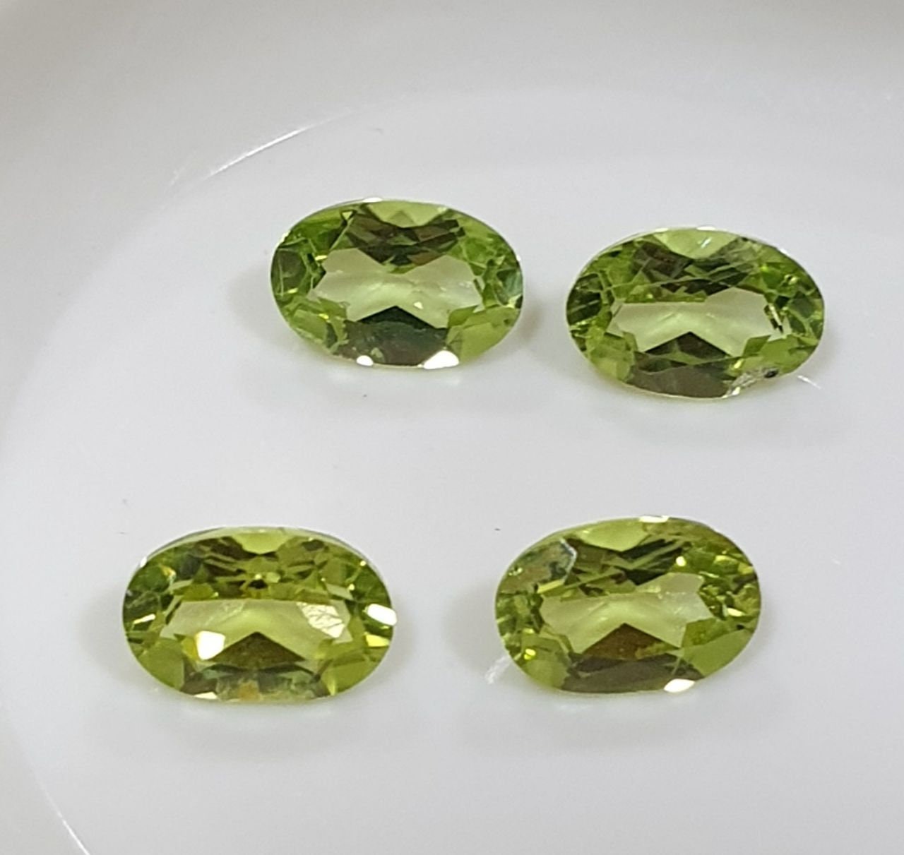 Lote de 4 peridotos de corte ovalado facetado de 6 x 4 mm, color verde olivino.