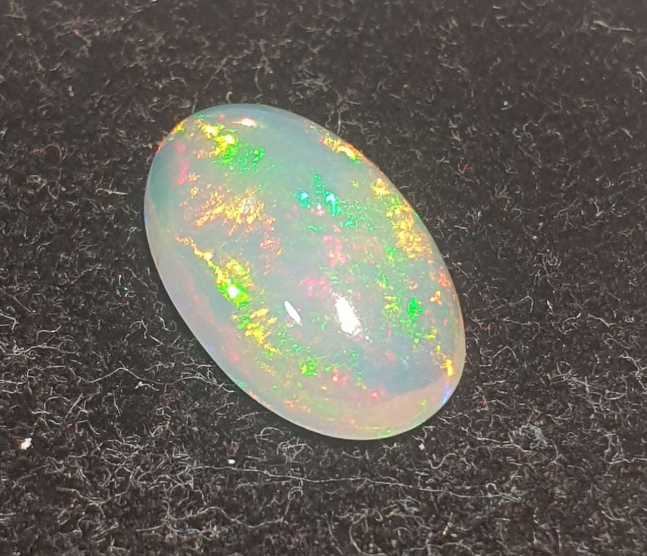 Cabujón ovalado de ópalo blanco AAA de 13,1 x 8 mm y 2,37 ct. Ópalo natural sin tratar. Gran intensidad de color. Talla excepcional.