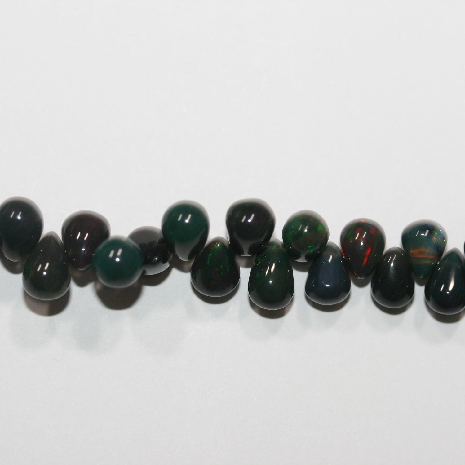 Cuentas de ópalo etíope negro de 8" con efecto degradado suave. 8 x 5 mm - 5 x 3,5 mm. Hilo de 20 cm. Ref. 14883