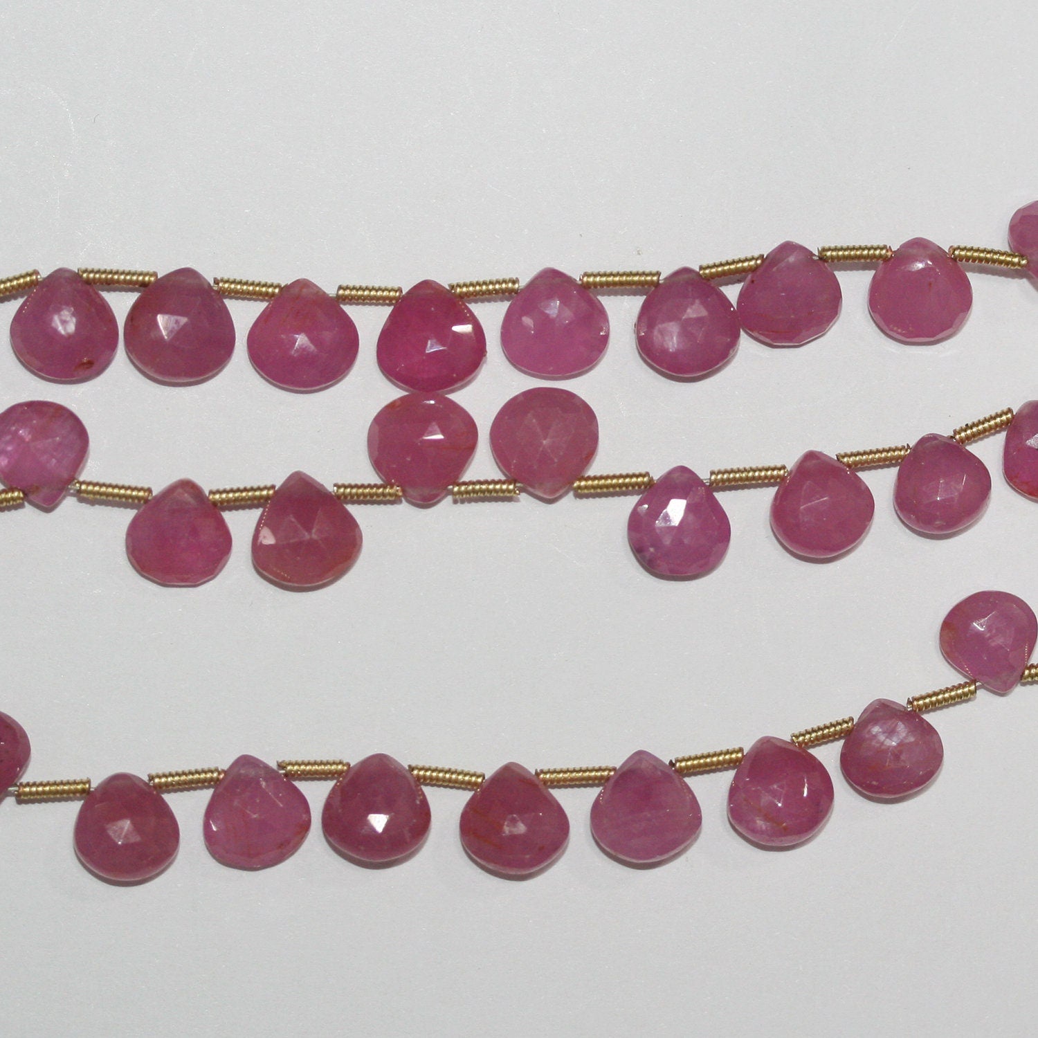 Perles en saphir rose St de taille dégradée, en forme de goutte, de 5 à 7 mm. Longueur approximative du fil : 21 cm.
