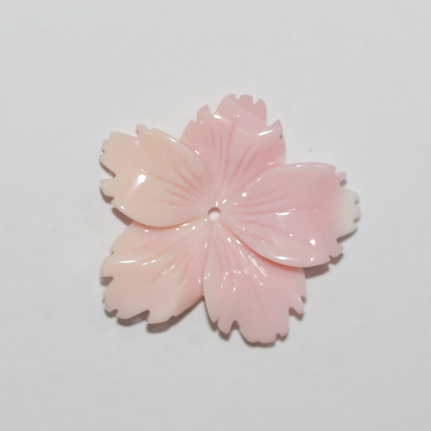 Pendentif feuille de coquillage rose naturel 25 mm environ.