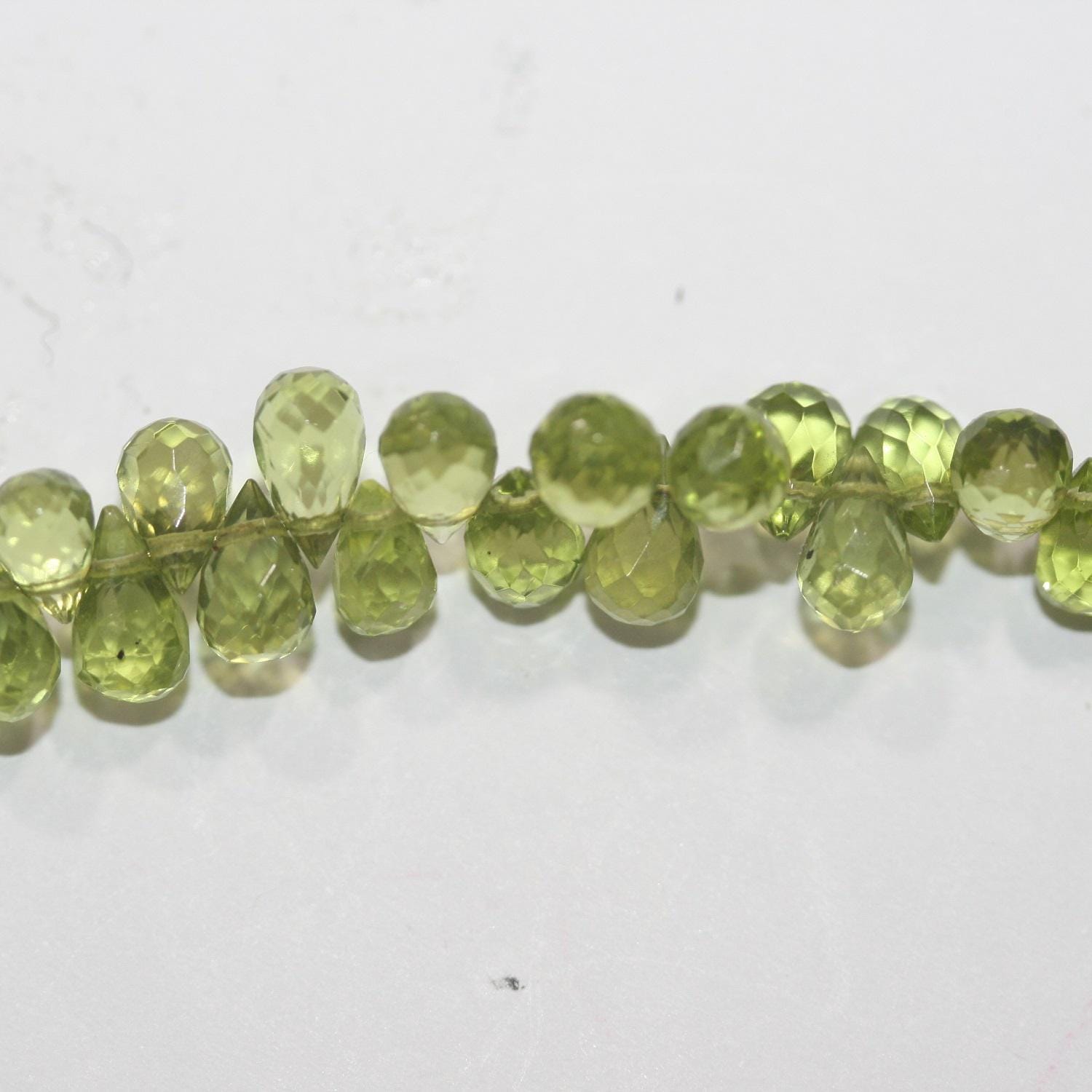 Perles en péridot facettées de 8 pouces (7 x 4 mm). Longueur approximative du fil : 20 cm.