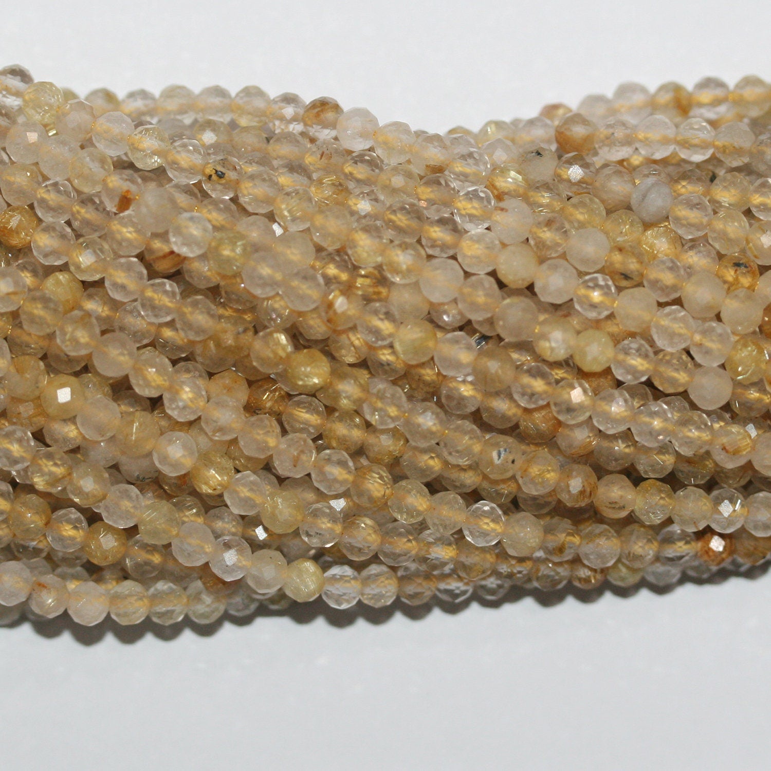 Perles rondes à facettes en quartz rutile St 15" 4 mm - Fil 39 cm.