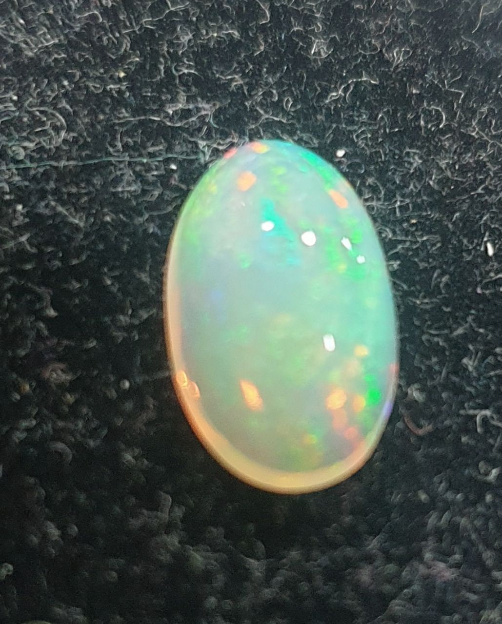 Cabujón ovalado de ópalo blanco AAA de 13,1 x 8 mm y 2,37 ct. Ópalo natural sin tratar. Gran intensidad de color. Talla excepcional.