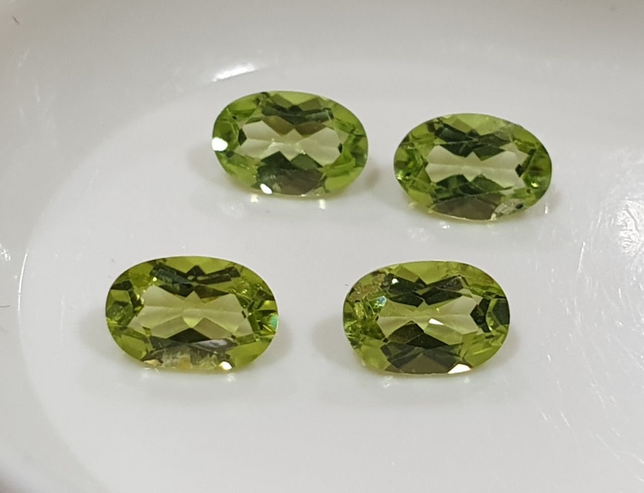 Lote de 4 peridotos de corte ovalado facetado de 6 x 4 mm, color verde olivino.