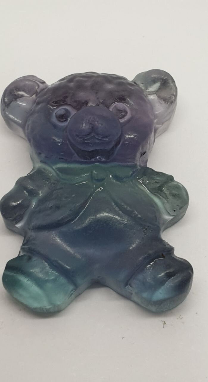 Colgante de fluorita tallada en forma de oso de peluche (26 x 20 mm). Con orificio para el colgante.