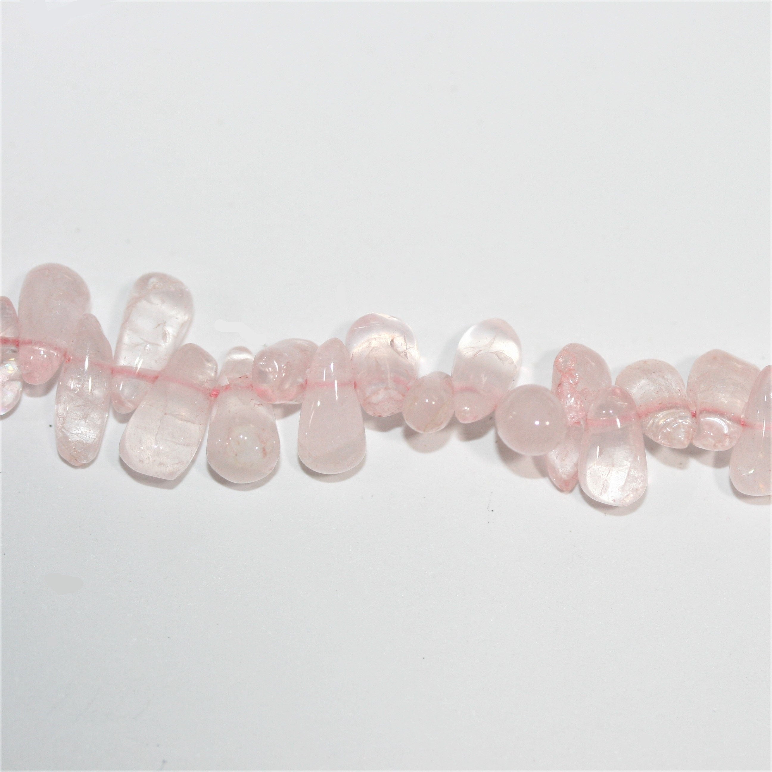 Perles en quartz rose lisses en forme de goutte, 10 x 5 mm environ - Longueur du fil : 36 cm.