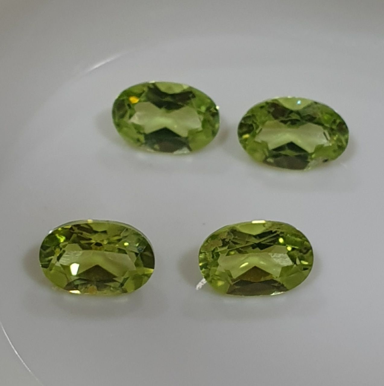 Lote de 4 peridotos de corte ovalado facetado de 6 x 4 mm, color verde olivino.