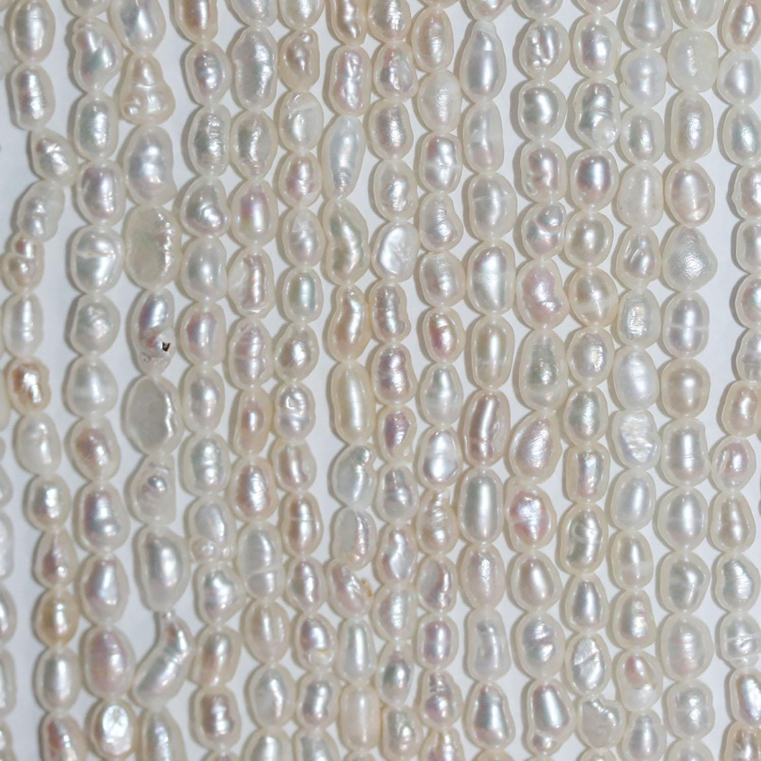 Perles ovales d'eau douce de 35 cm (14 pouces), 3-4 mm, en rang de 35 cm. Perles naturelles à prix de gros.