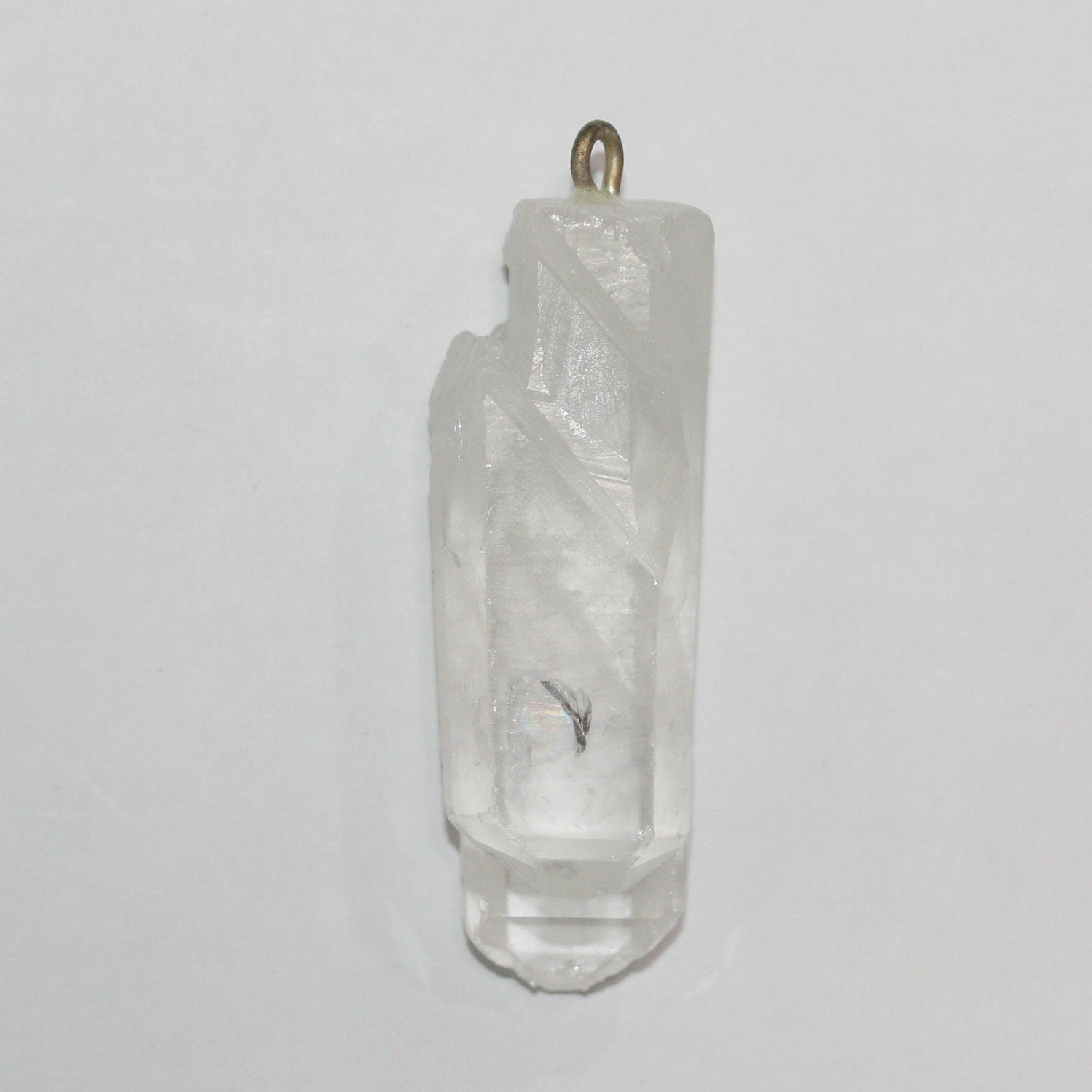 Pendentif bâtonnet irrégulier à facettes en quartz cristal de roche non poli, 55 x 18 mm environ.