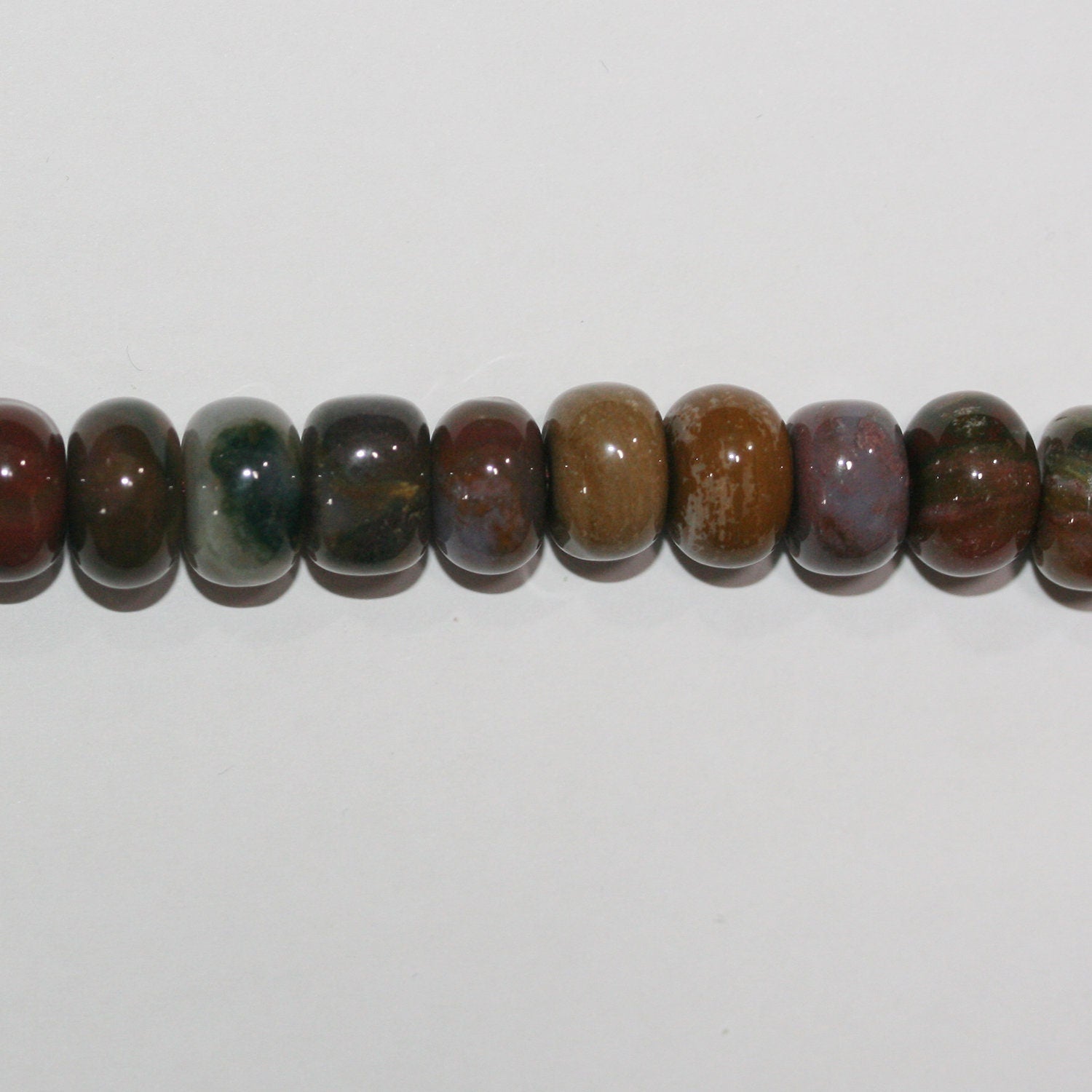 Perles rondelles lisses irrégulières en jaspe océanique de 15 pouces (10 x 6 mm). Longueur approximative du fil : 39 cm.