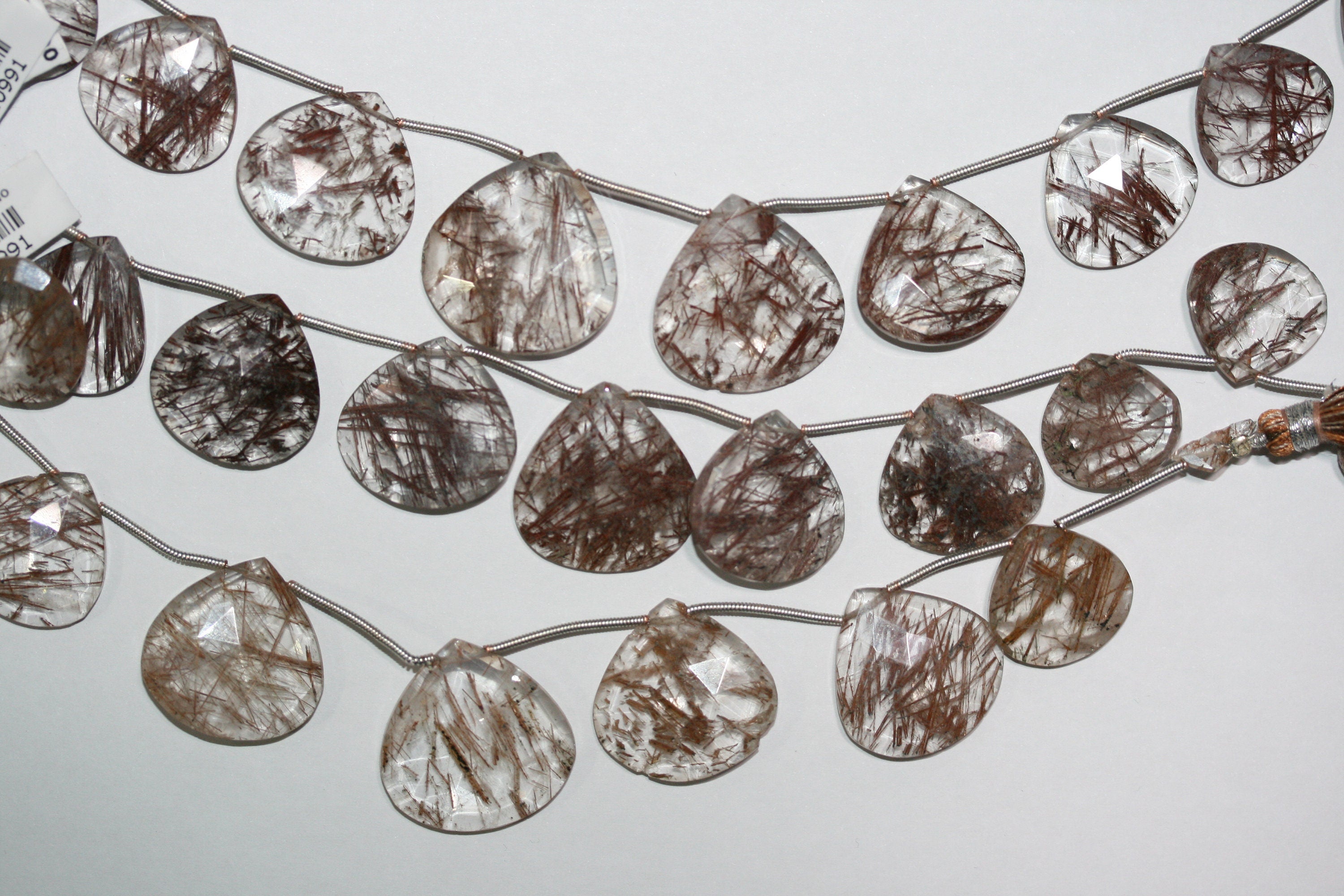 Perles en quartz rutile St de taille graduée, facettées, en forme de goutte, de 18 à 25 mm environ - Longueur du brin : 20 cm.