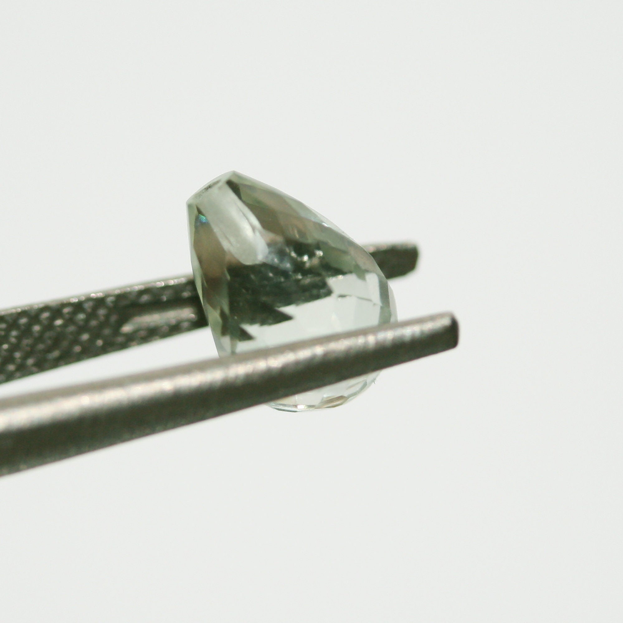 Paire de perles en prasiolite demi-percées, taillées en briolette facettée, 10 x 7 mm. Améthyste verte