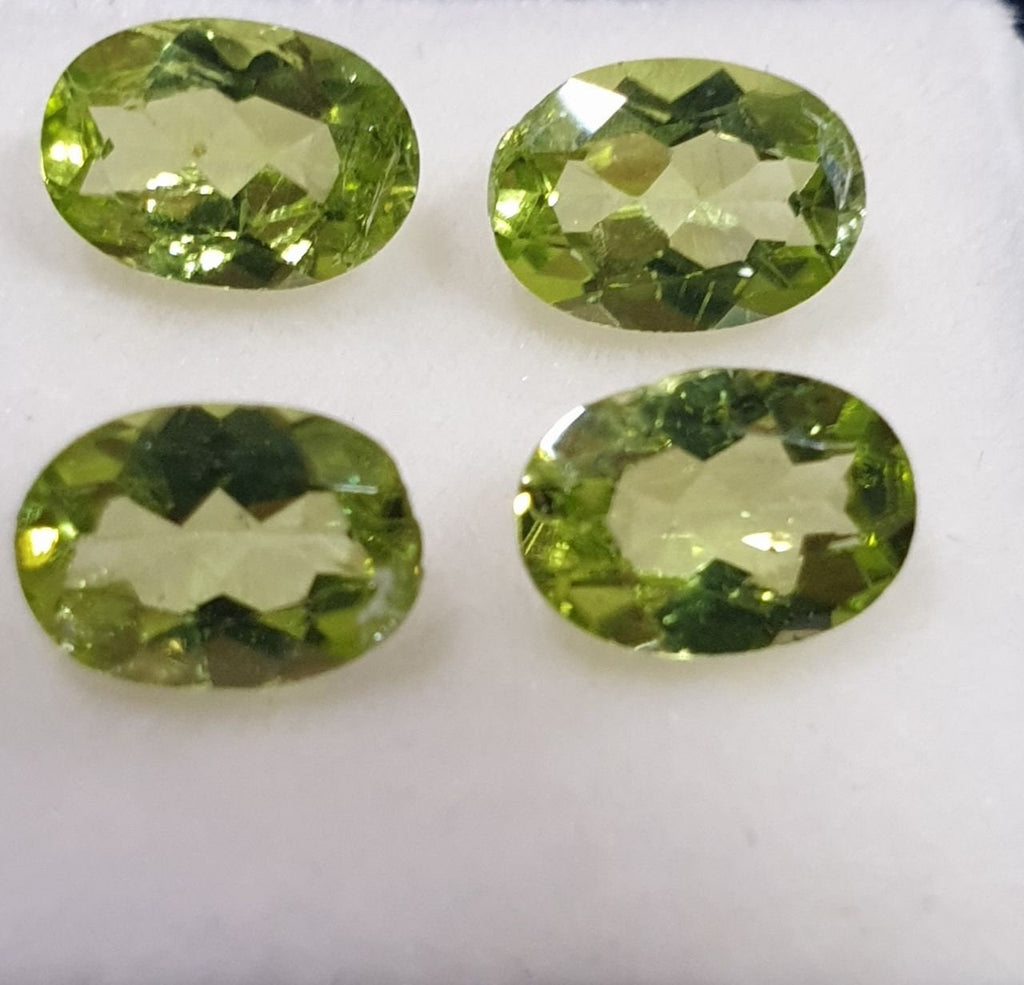 Lote de 4 peridotos de corte ovalado facetado de 7 x 5 mm, color verde olivino.