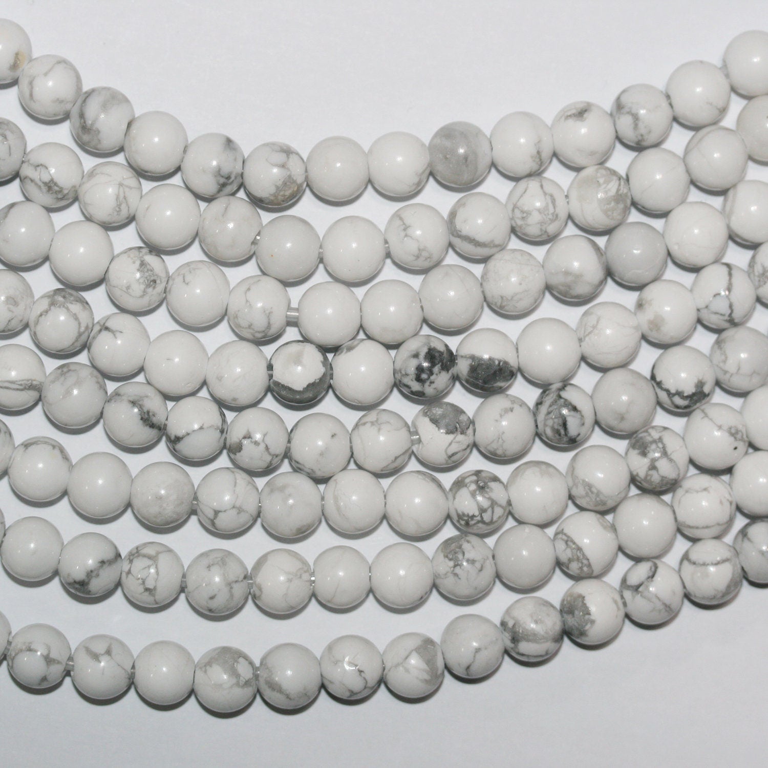 Perles rondes lisses en howlite blanche St 14" 8 mm - Percées à 2,50 mm - Fil de 36 cm.