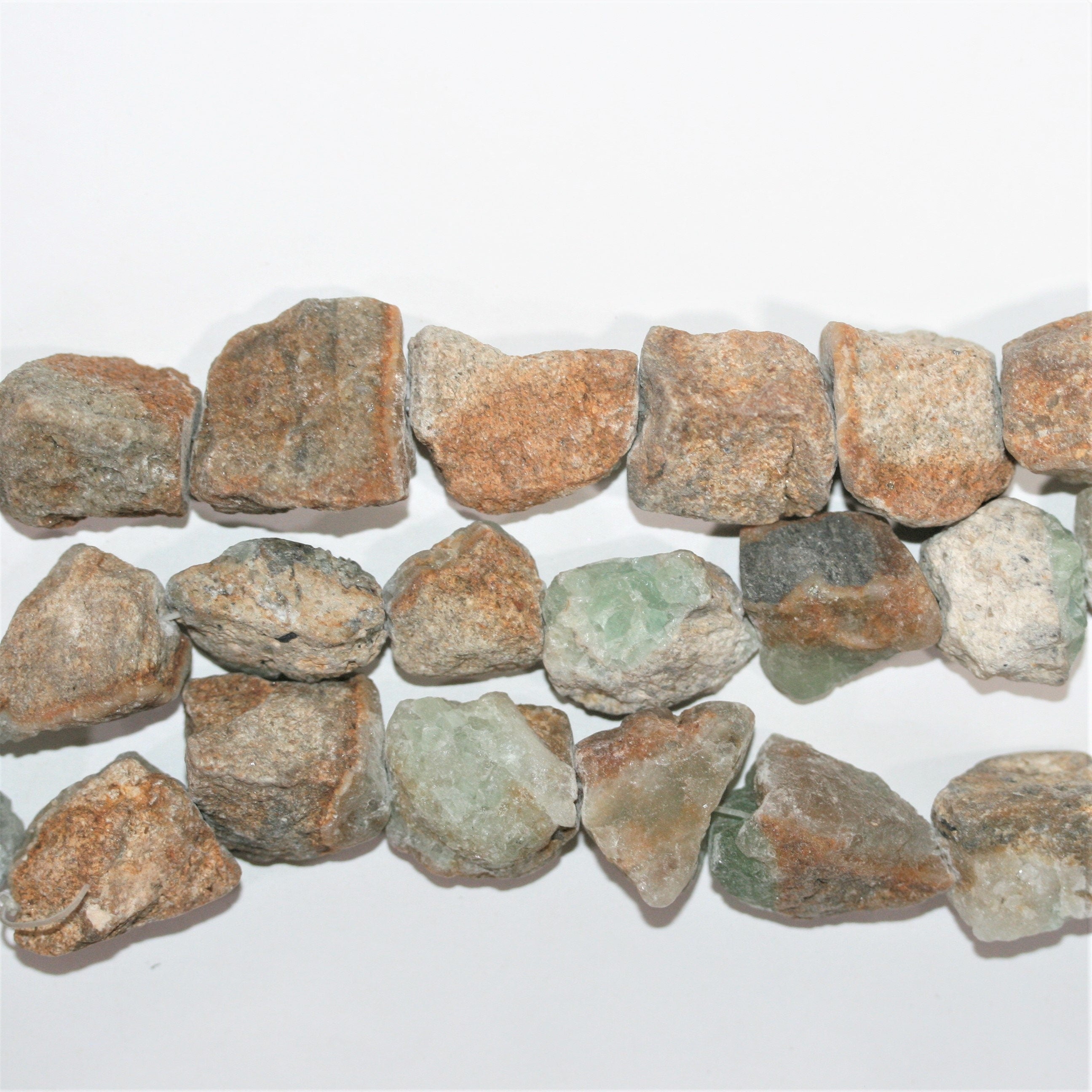 Perles de fluorite non polies en forme de pépites, 23 x 20 mm. Longueur approximative du fil : 39 cm.