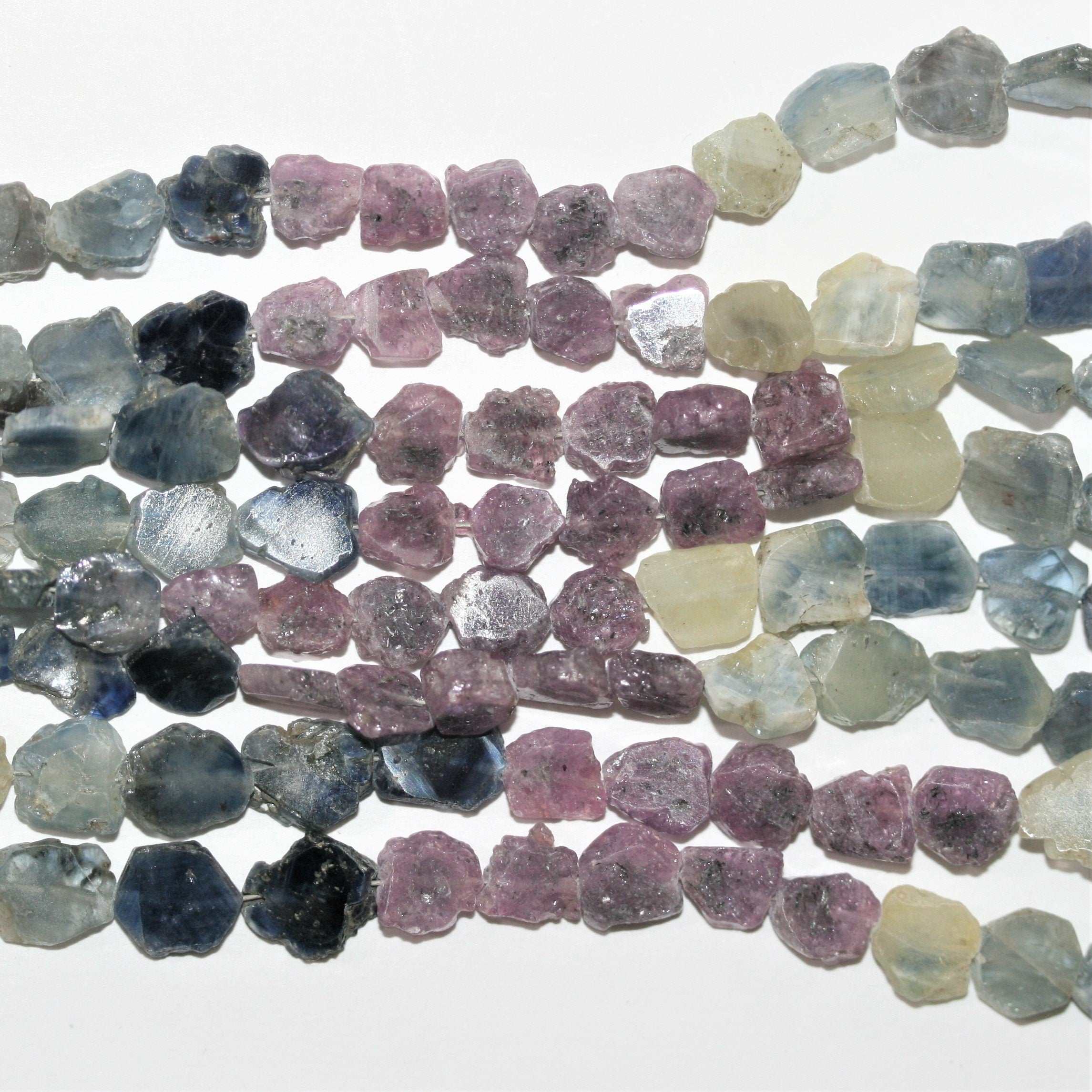 Perles ovales lisses et irrégulières en saphirs multicolores, de 6 à 8 mm environ. Longueur du fil : 40 cm environ.