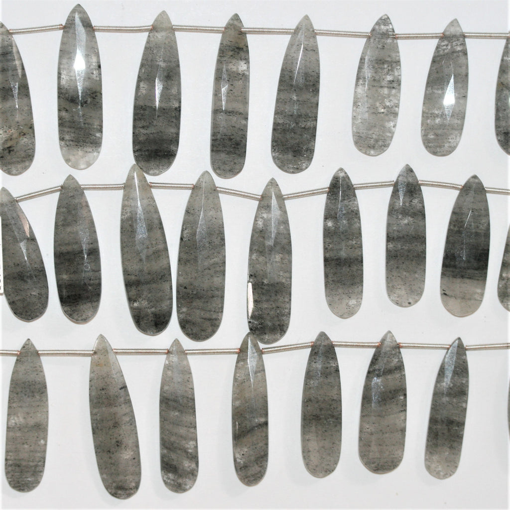 Perles en quartz tourmaliné St de taille graduée, en forme de goutte, à facettes, de 32 x 11 à 42 x 12 mm. Longueur approximative du brin : 20 cm.